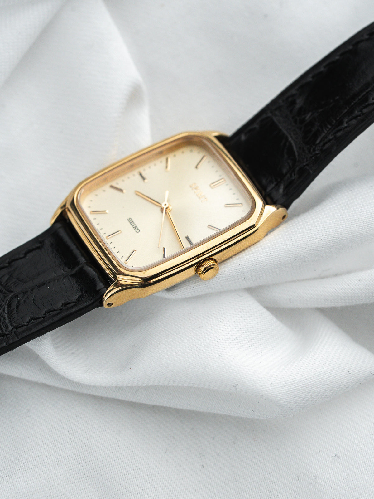 Montre Seiko vintage, boîtier rectangulaire plaqué or, cadran crème et bracelet cuir noir