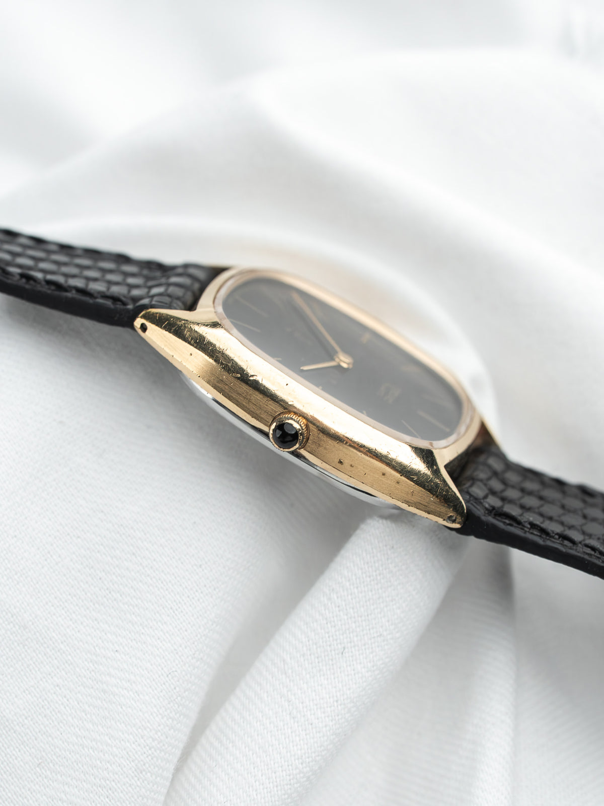 Montre Omega vintage, boîtier doré rectangulaire, cadran noir et bracelet cuir noir