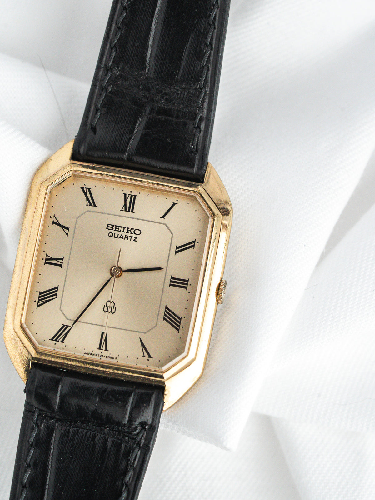 Seiko Quartz vintage watch with gold case, cream dial, Roman numerals, black leather strap
