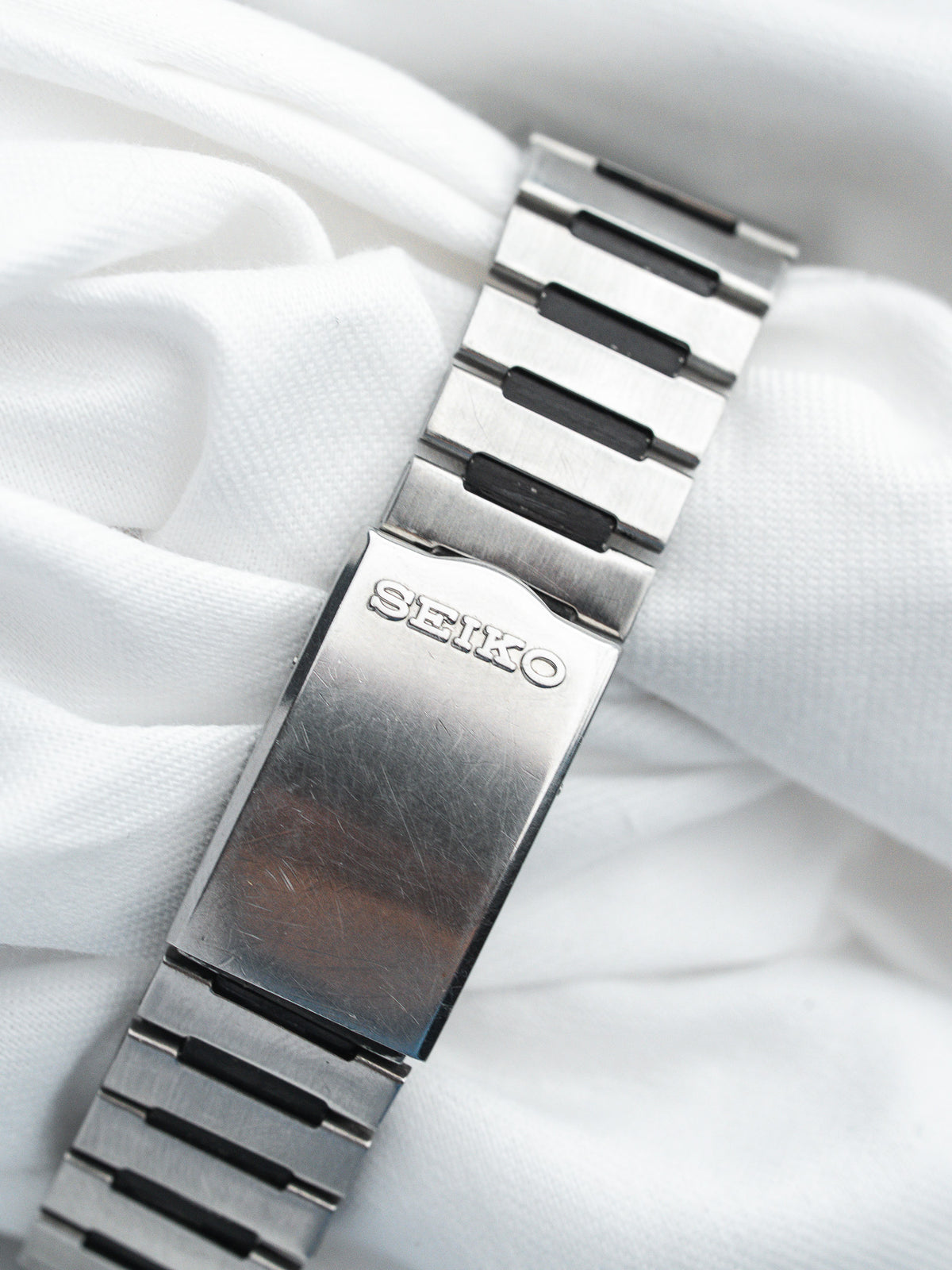 Seiko vintage watch bracelet with brushed steel links and black accents