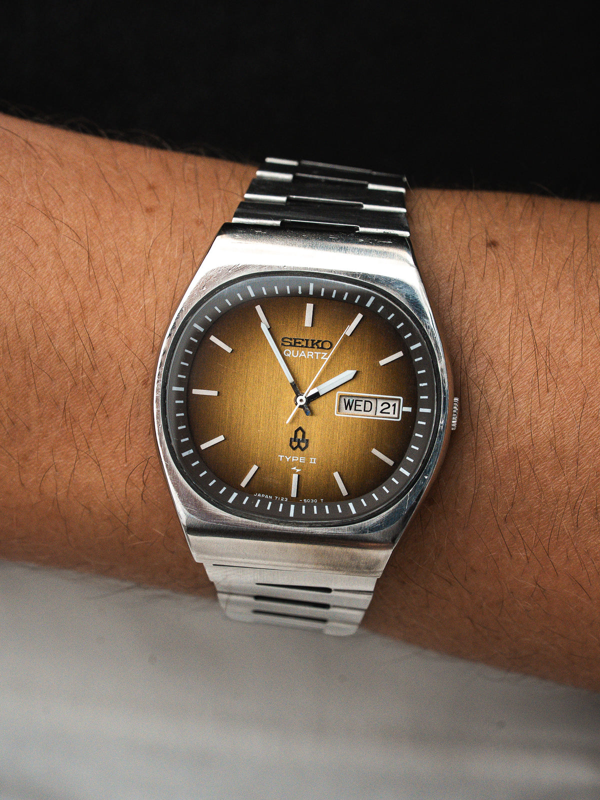 Montre Seiko Quartz vintage en acier, cadran doré, portée au poignet