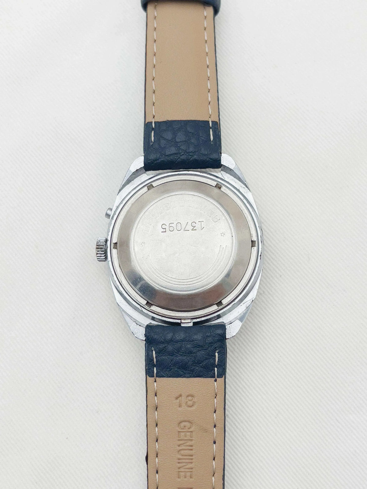 Vintage Omega watch back with engraved serial number, steel case, blue leather strap