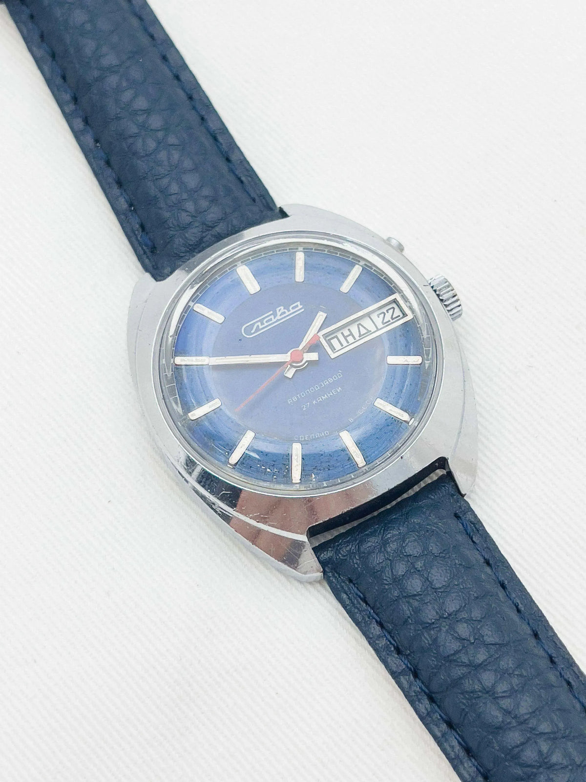Slava vintage watch with blue dial, date window, and dark blue leather strap