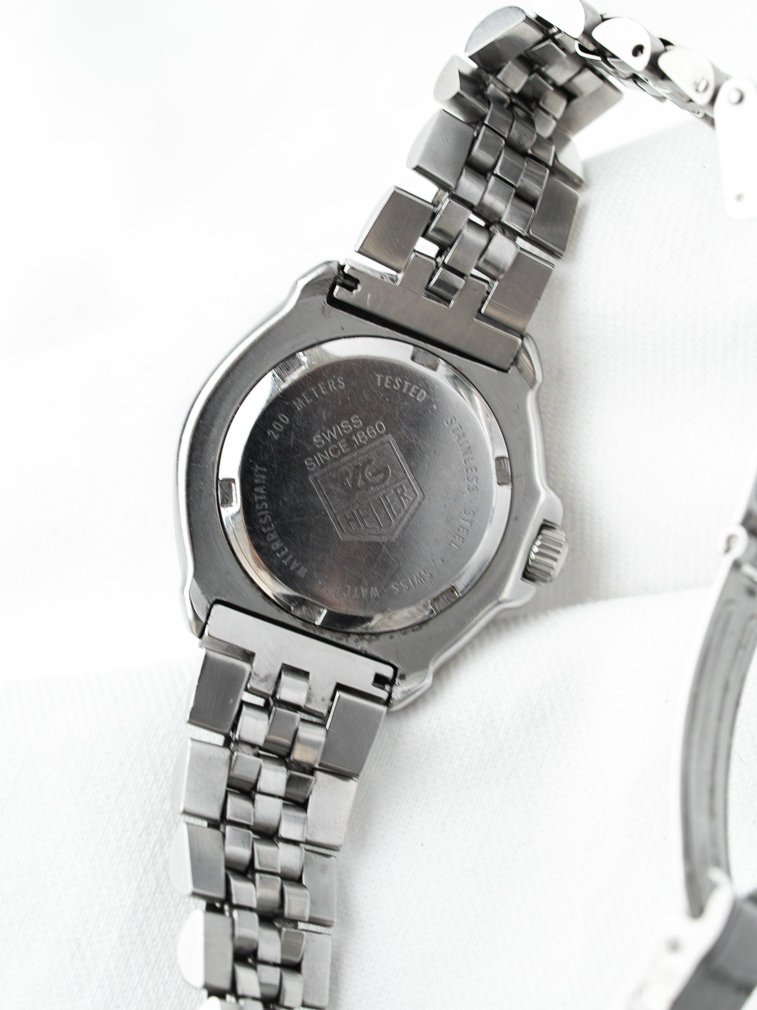 TAG Heuer vintage watch back, stainless steel case, engraved logo, white background