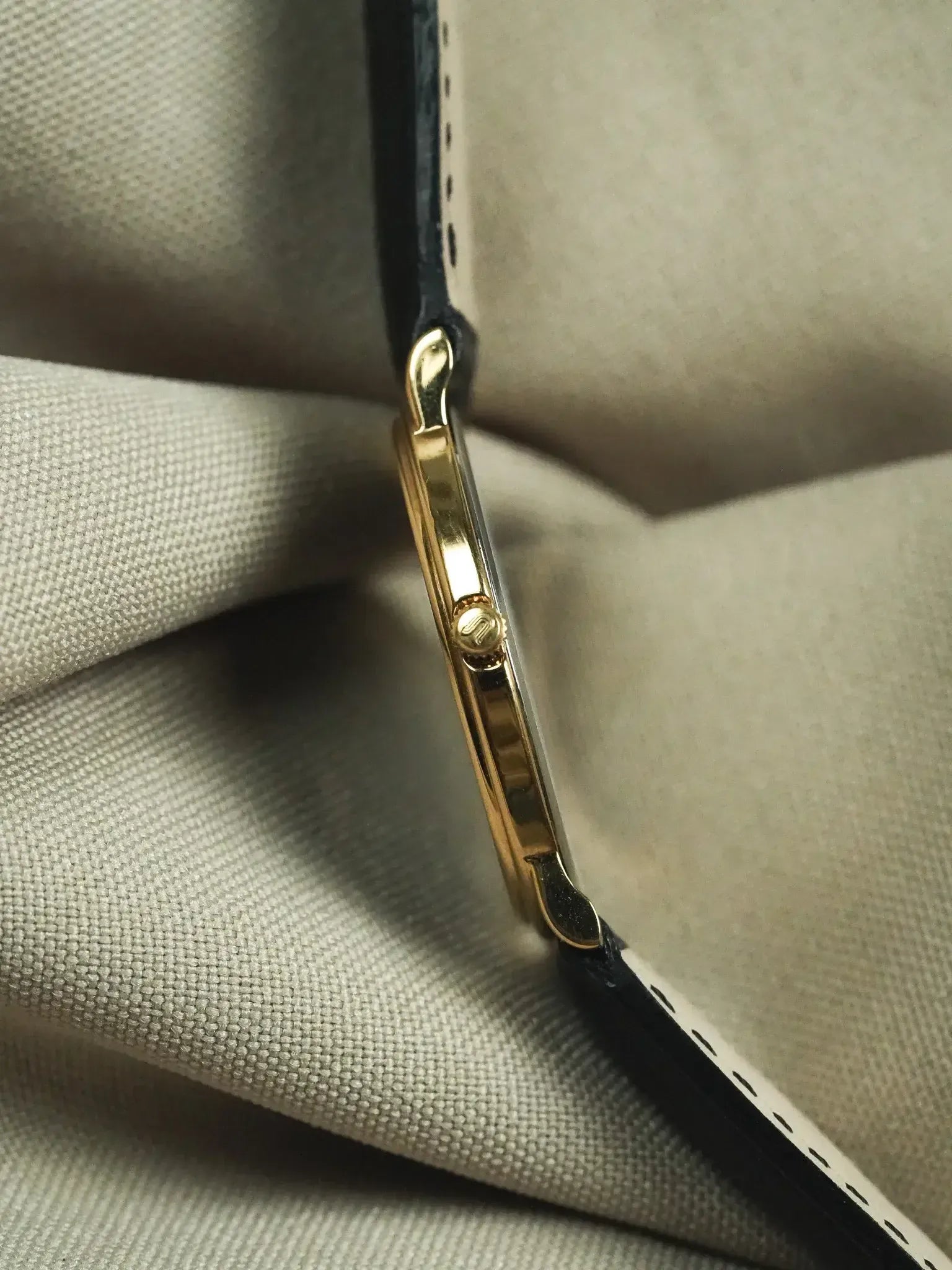 Cartier Tank vintage gold case with black leather strap on fabric