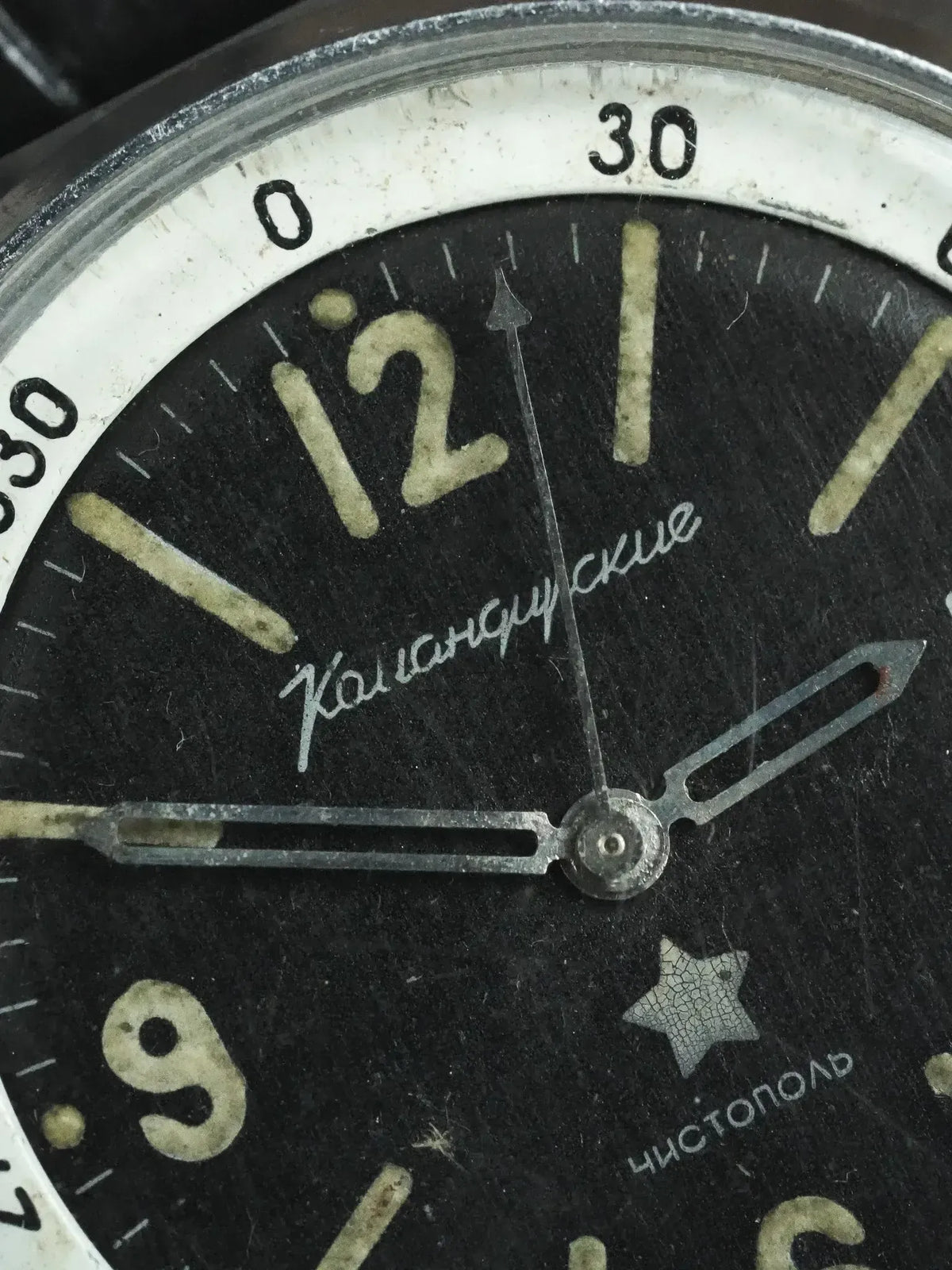 Vintage Soviet watch with black dial, Cyrillic text, and star marker