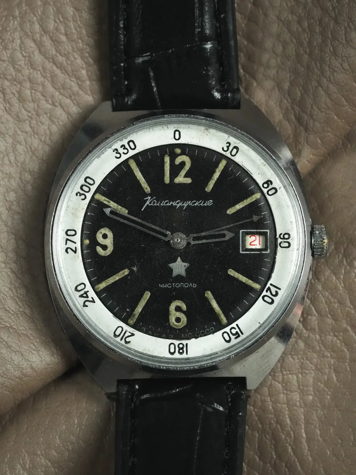 Vintage Komandirskie watch with black dial, luminous markers, and black leather strap