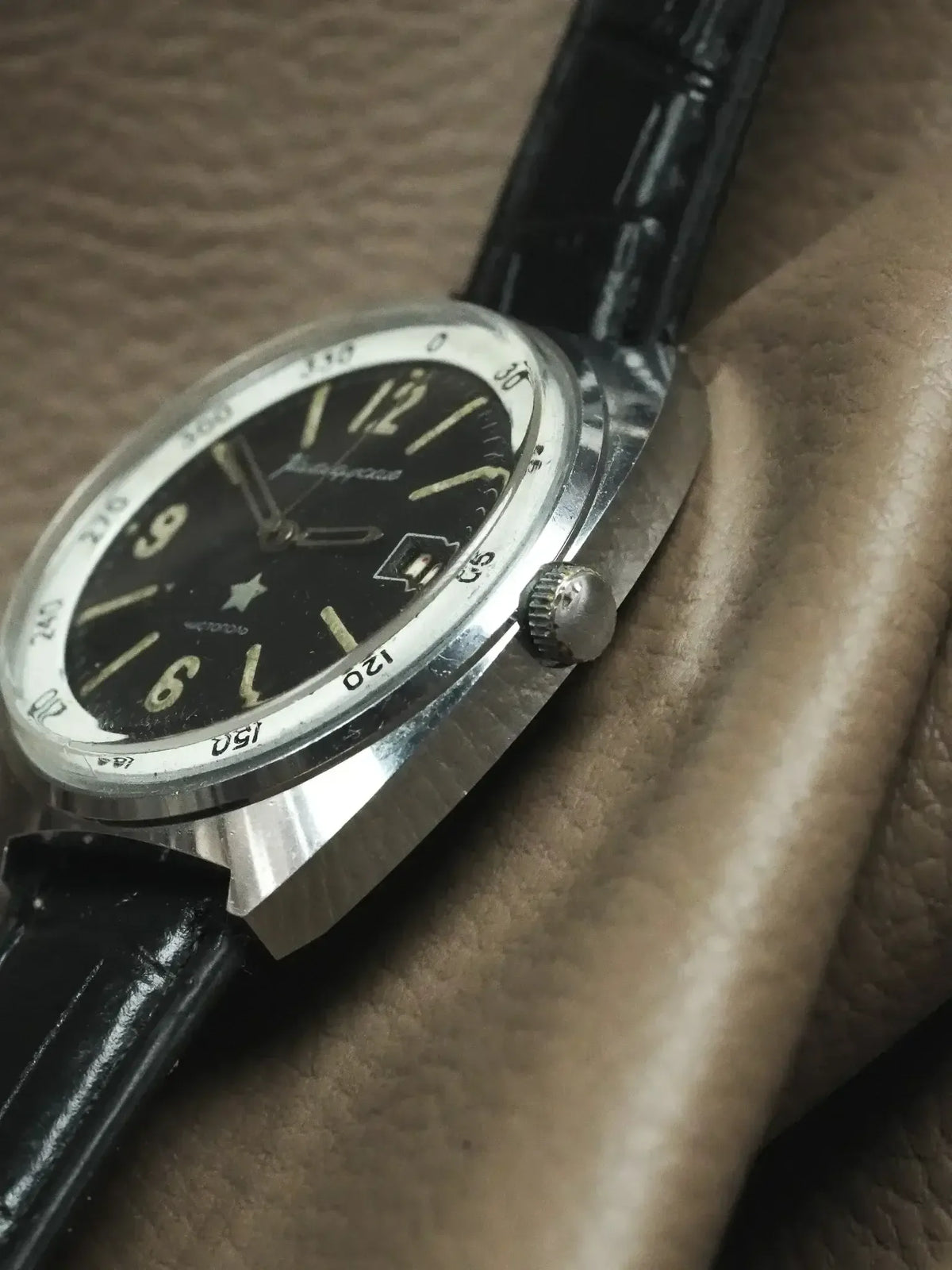 Vintage Poljot chronograph watch with black dial, steel case, and black leather strap