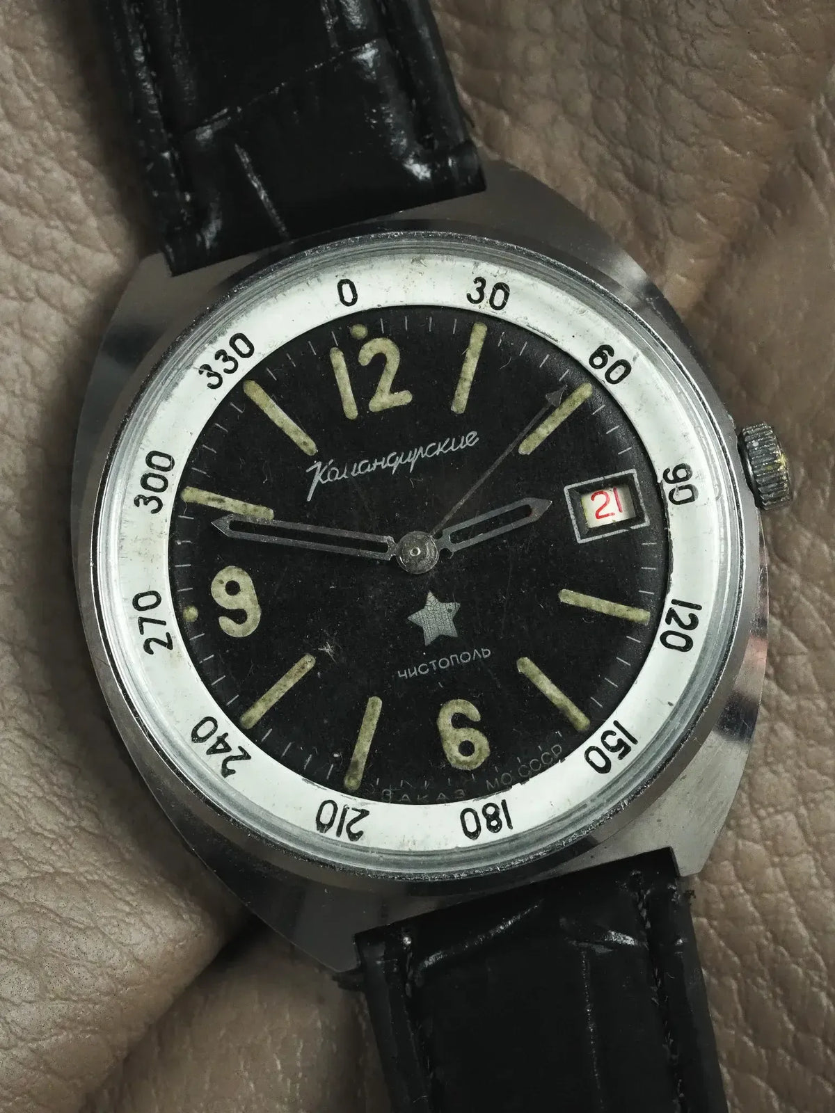 Vintage Vostok Komandirskie watch with black dial, luminous markers, and black leather strap