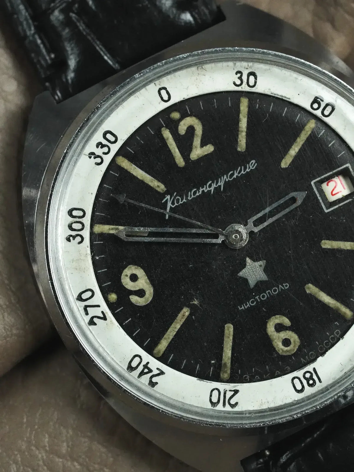 Vintage Vostok Komandirskie watch with black dial, luminous markers, and date window