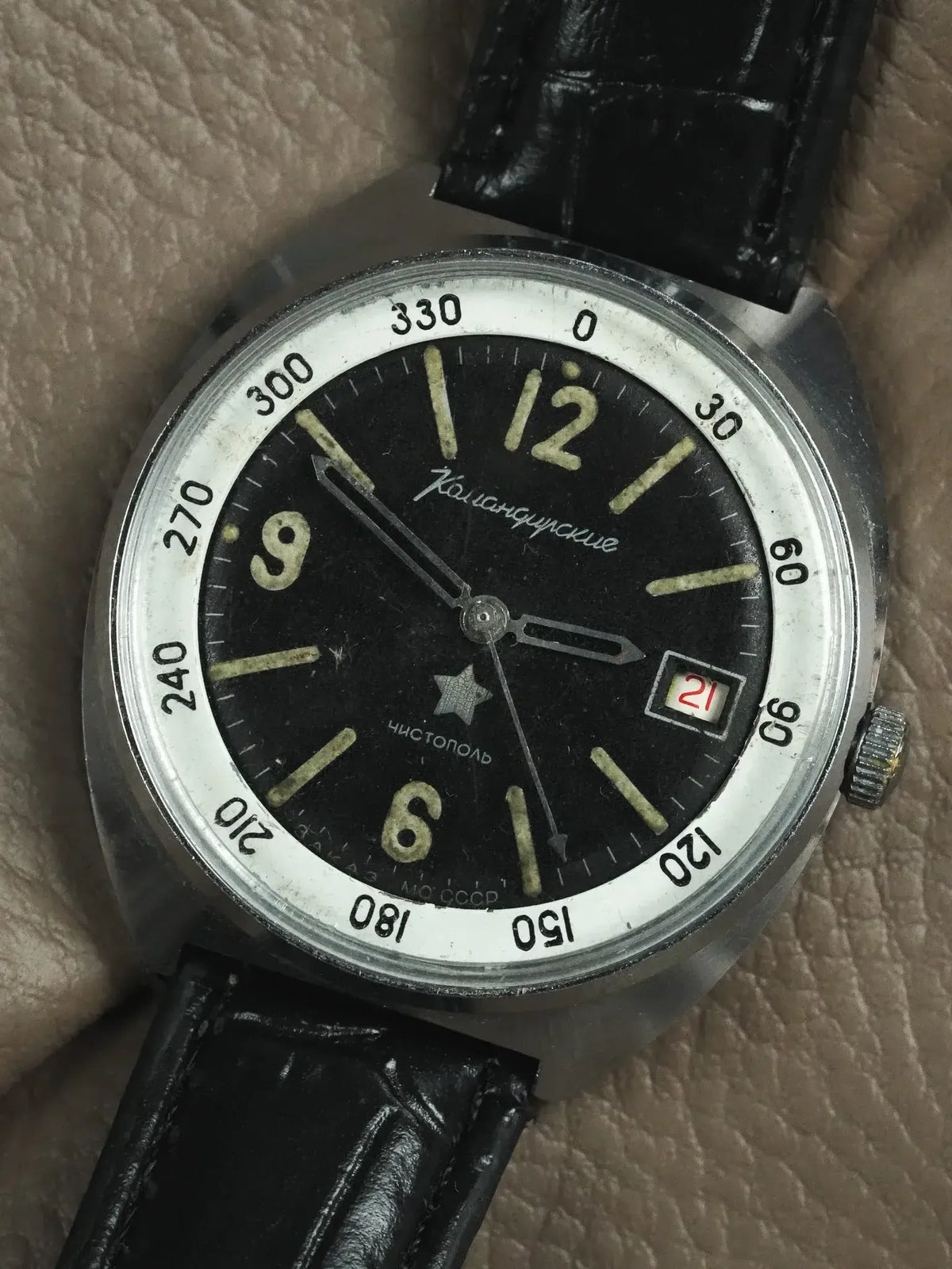 Vintage Komandirskie watch with black dial, luminous markers, date window, and black leather strap