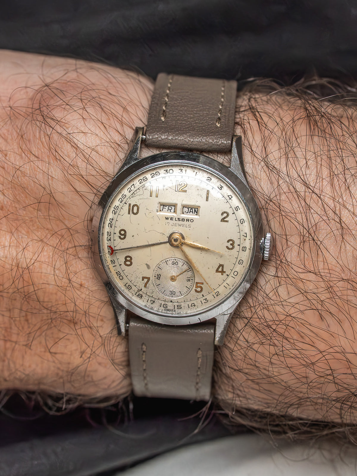 Vintage Welsbro wristwatch with cream dial, day-date, and brown leather strap on wrist