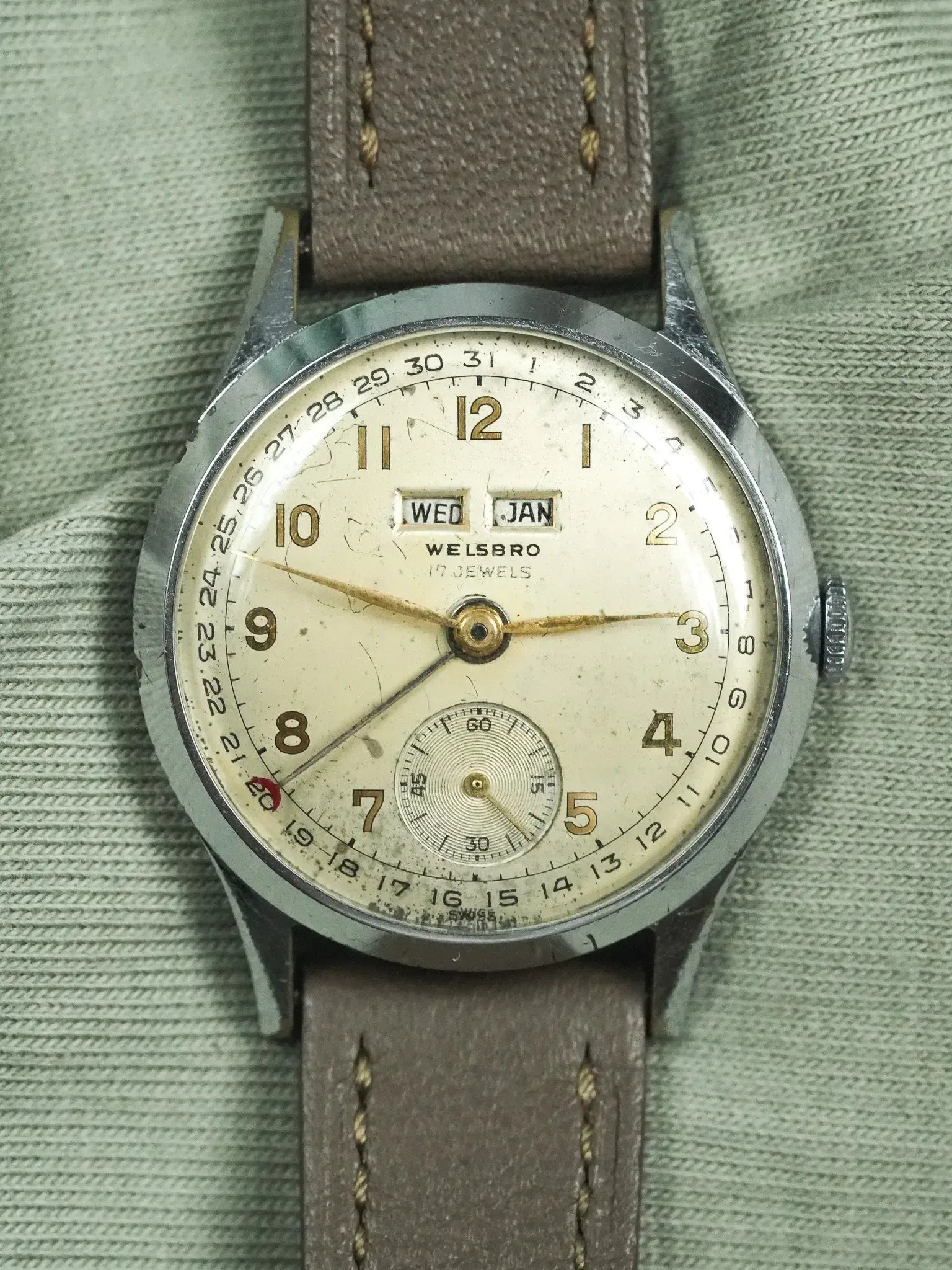 Vintage Welsbro wristwatch with cream dial, day-date window, and brown leather strap