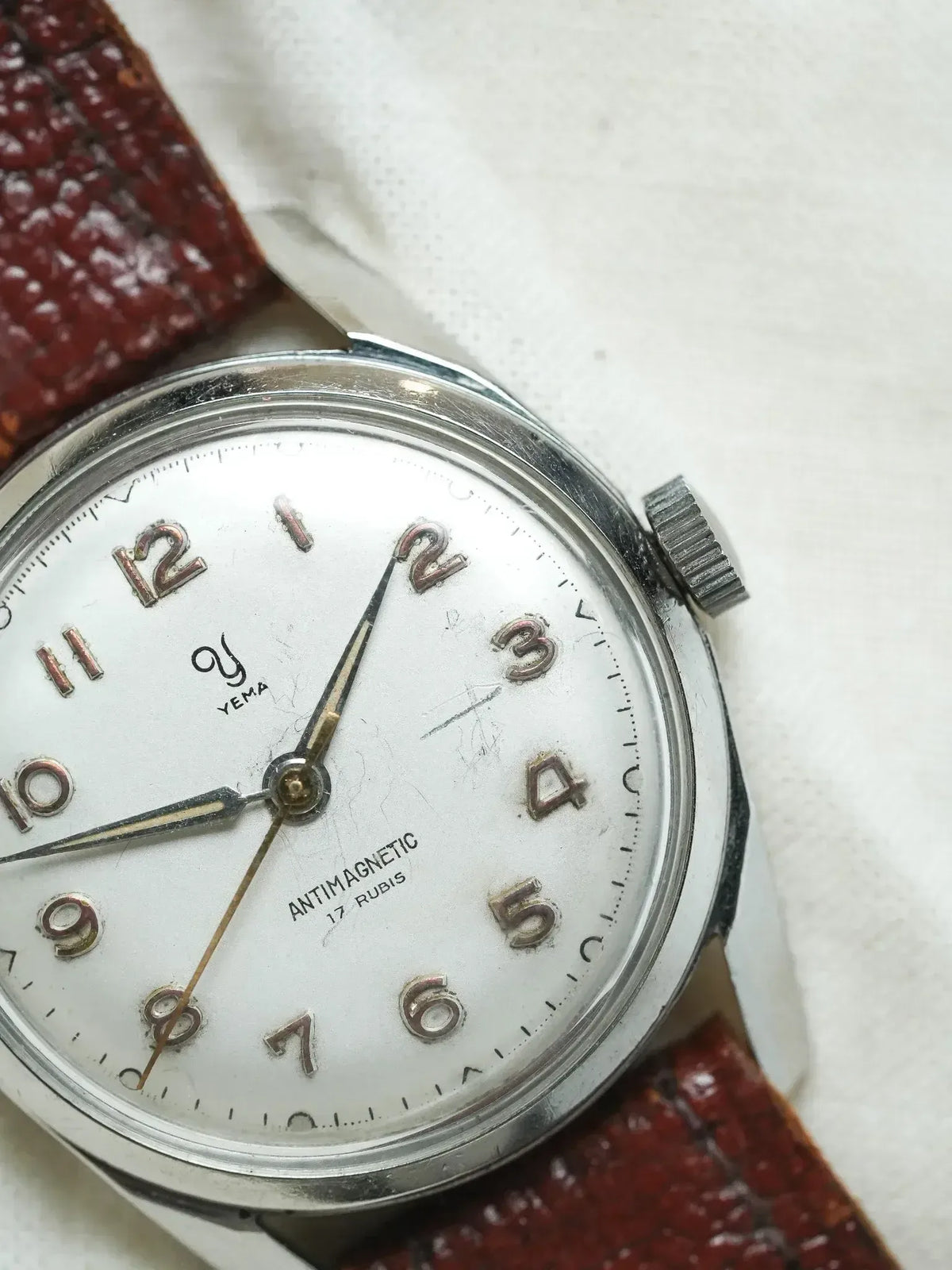 Vintage Yema antimagnetic watch with white dial, steel case, and brown leather strap