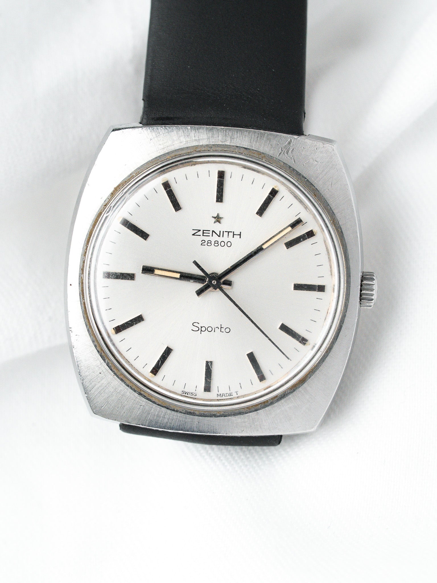 Vintage Zenith Sporto watch with white dial, black markers, and black leather strap