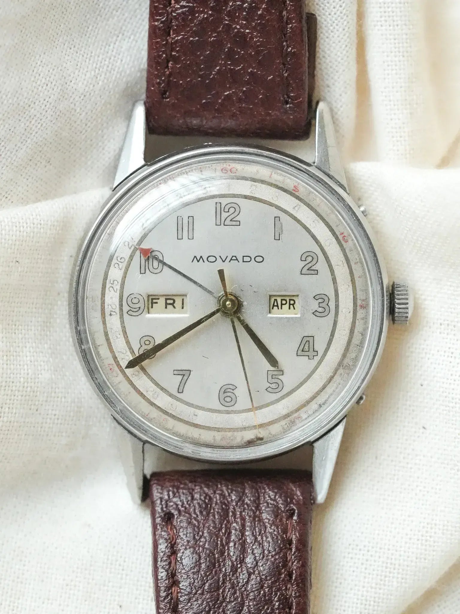 Vintage Movado watch with white dial, brown leather strap, day and date windows