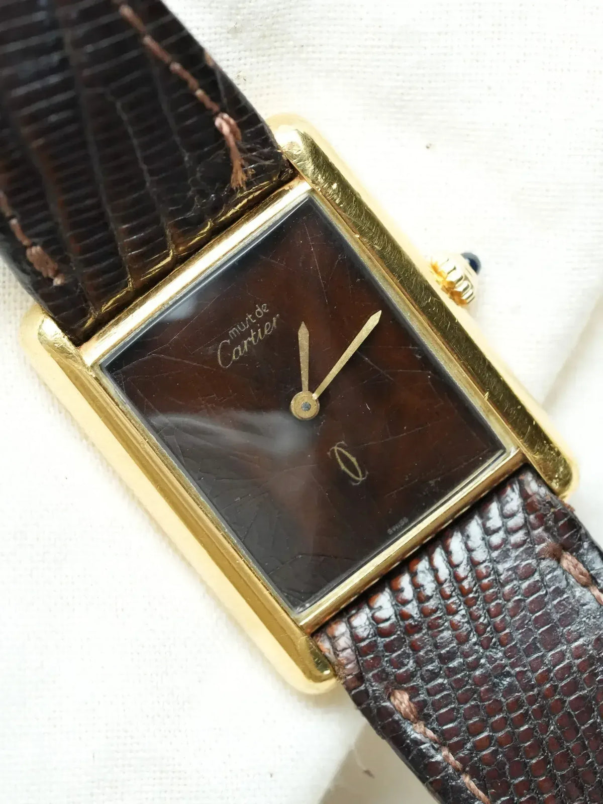 Cartier vintage watch with gold case, brown dial, and textured leather strap