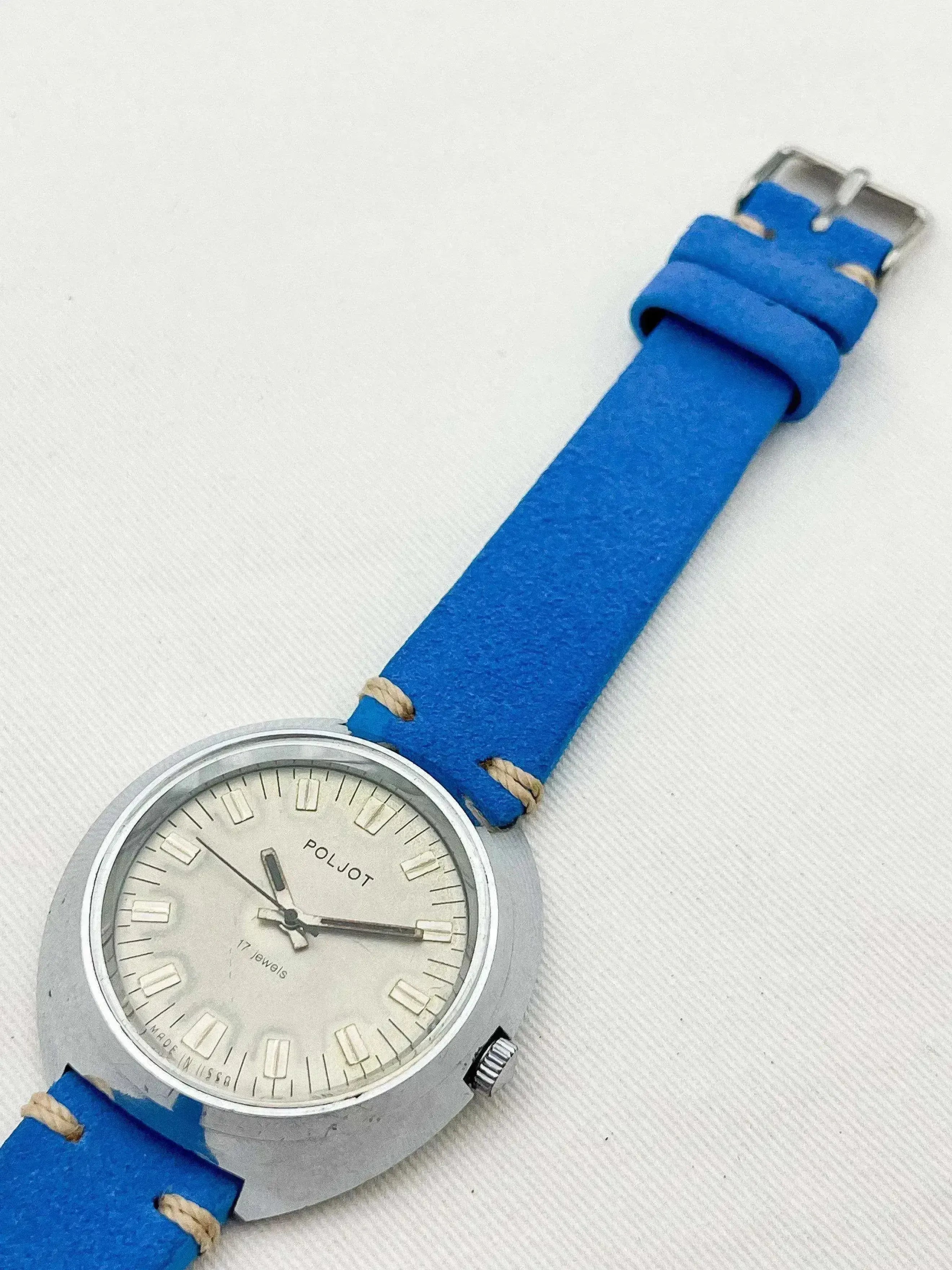 Vintage Poljot watch with silver dial and bright blue strap on white background