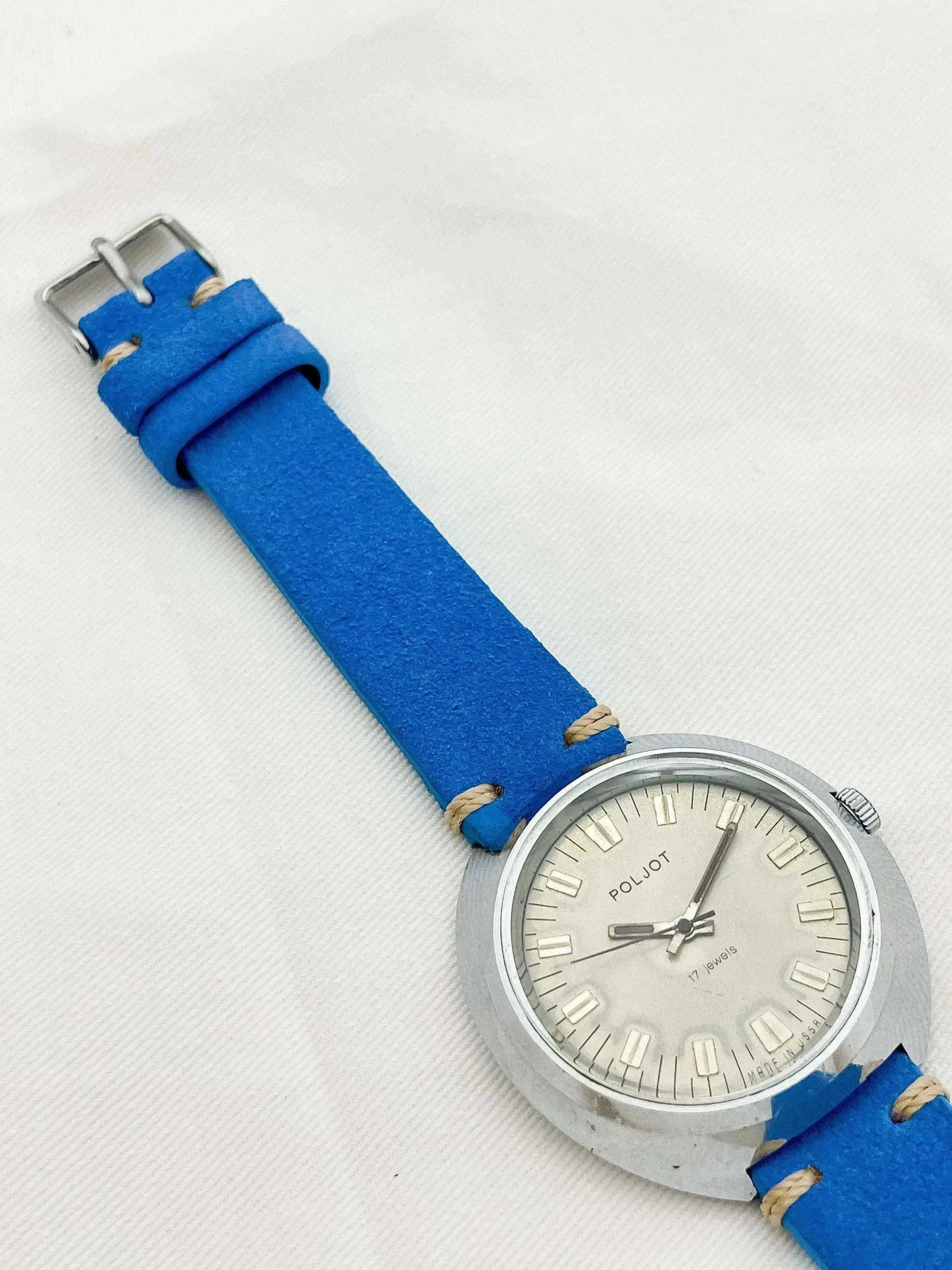 Poljot vintage watch with blue strap, silver case, and cream dial