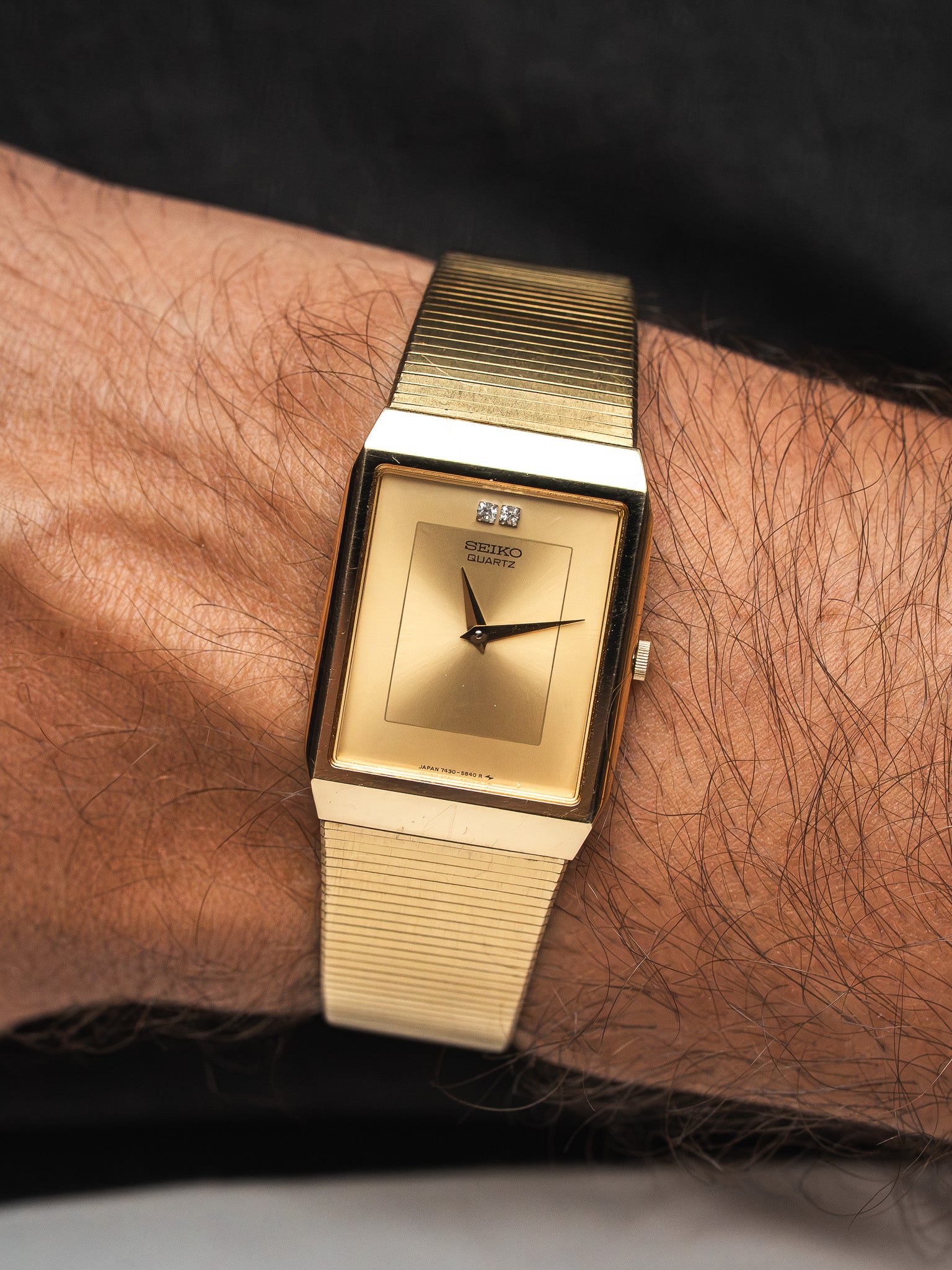 Seiko Quartz vintage watch with gold dial and textured bracelet worn on wrist