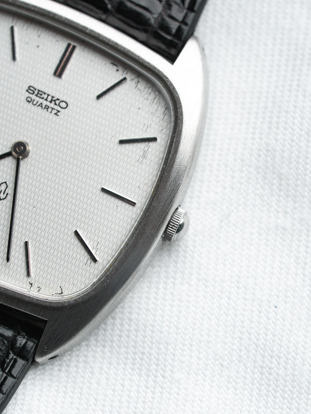 Seiko Quartz vintage watch with silver dial, black strap, and textured case