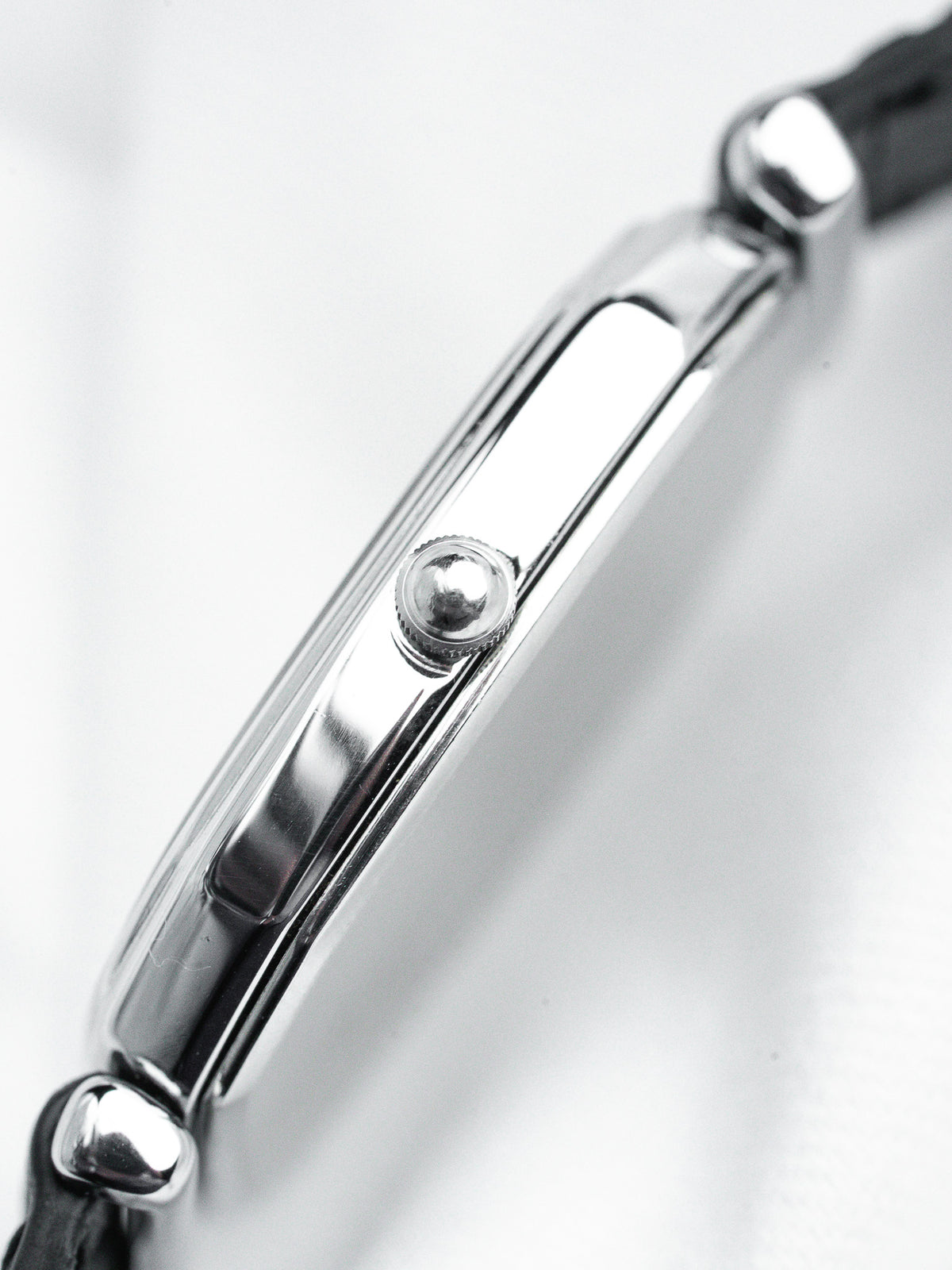 Cartier Tank vintage watch side view, polished steel case, black leather strap