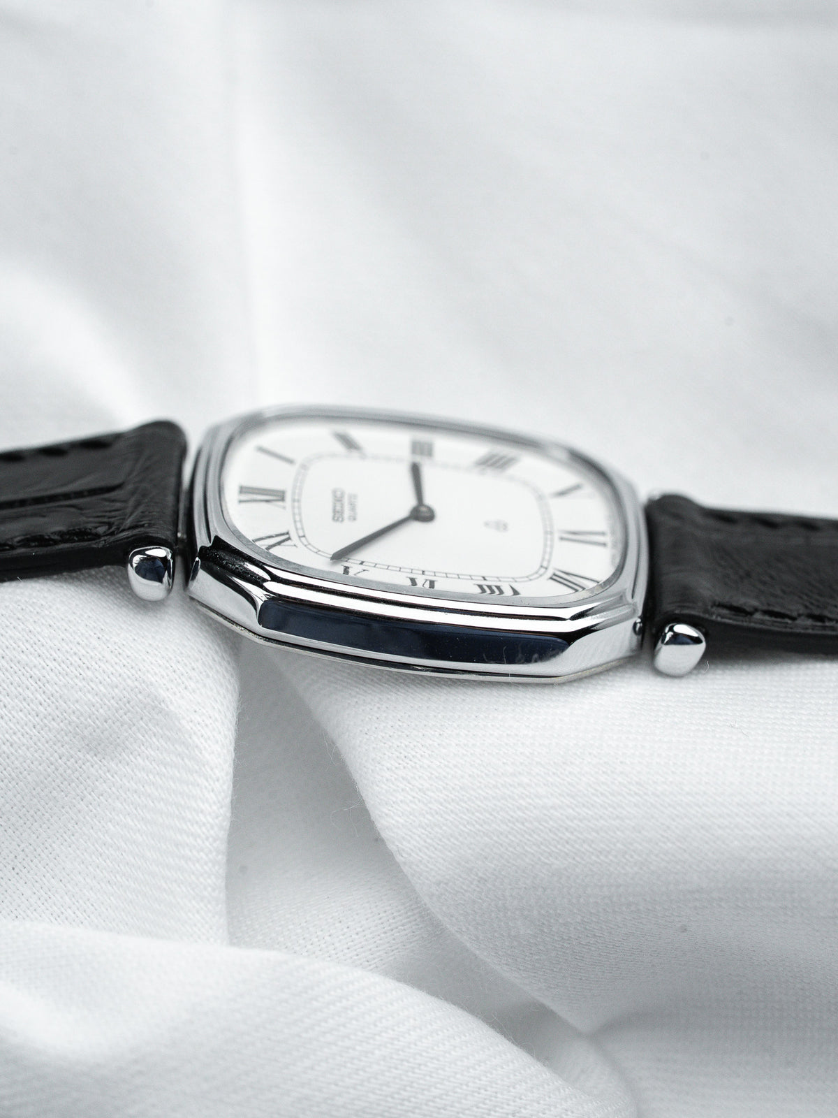 Seiko vintage watch with white dial, Roman numerals, black leather strap