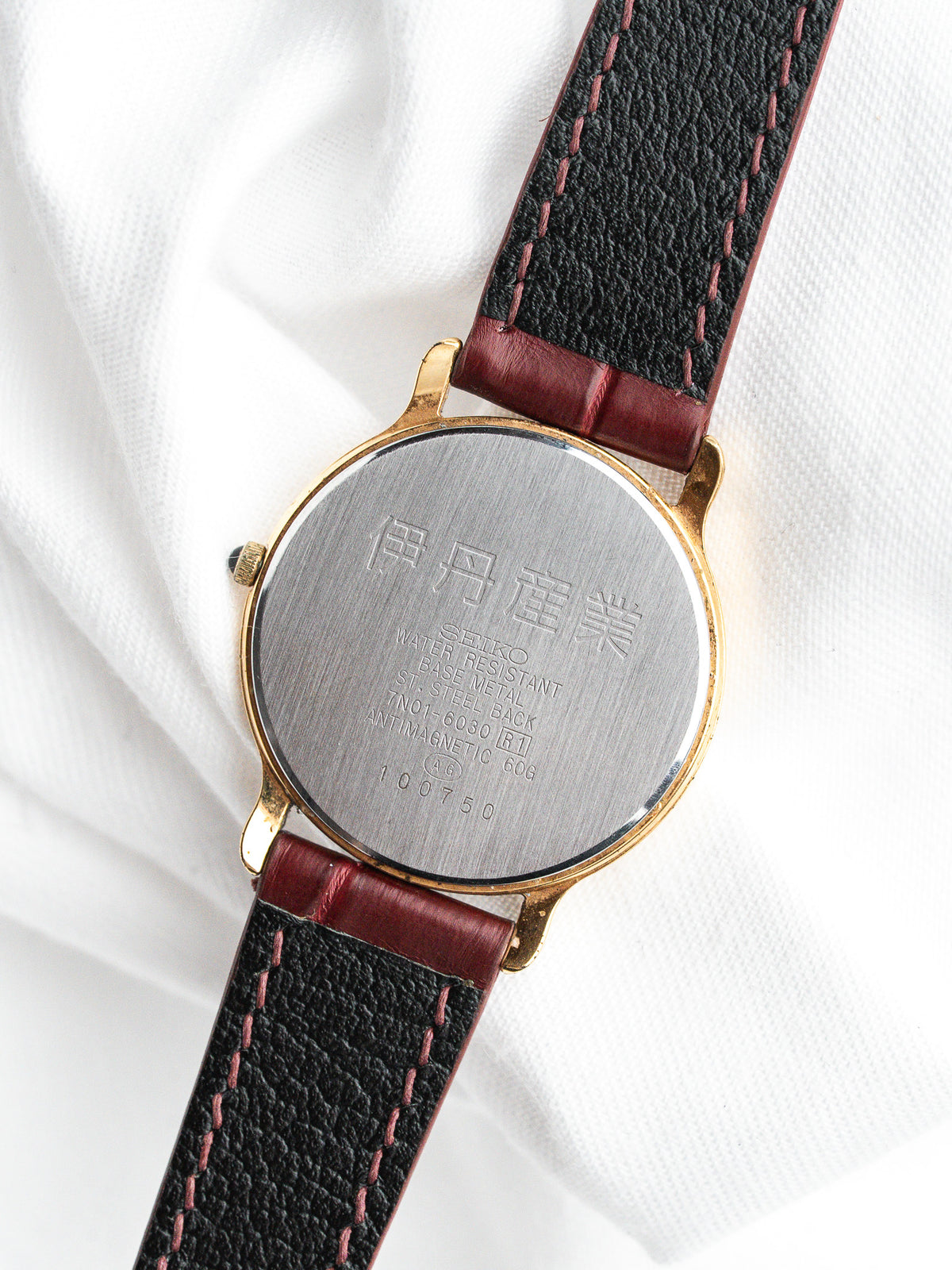 Seiko vintage watch with gold case, black leather strap, and engraved back