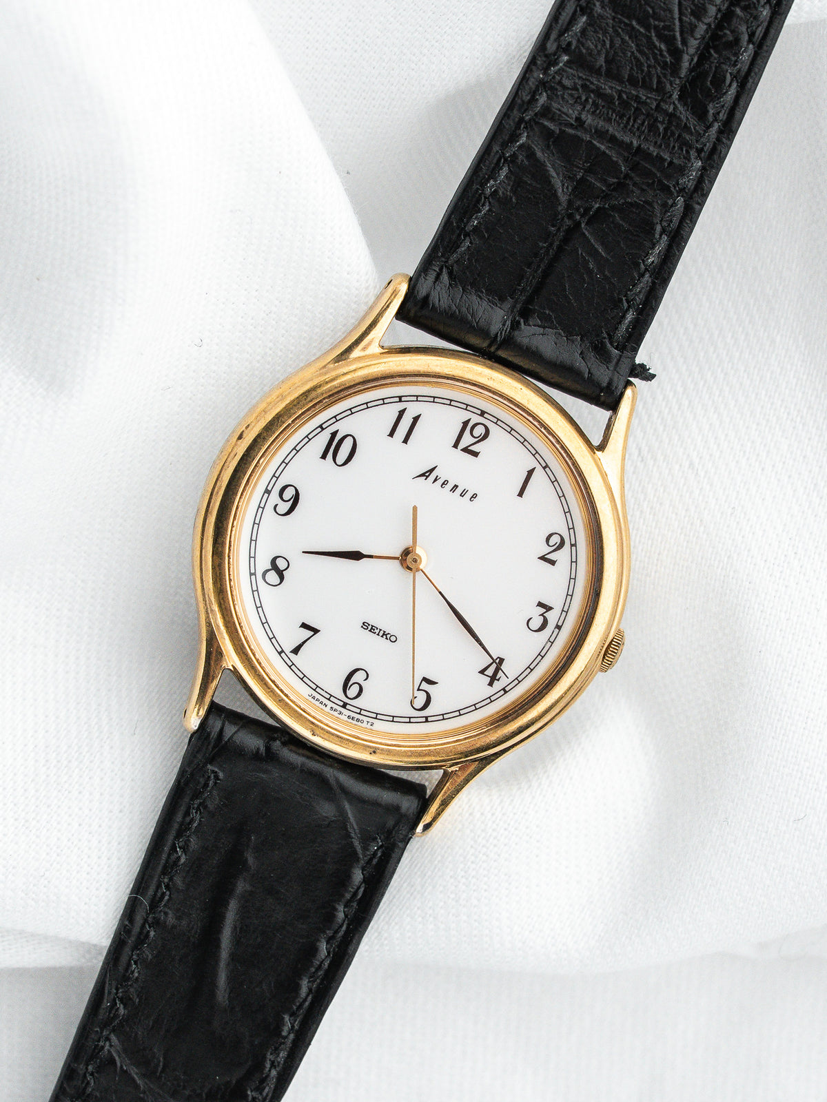 Montre Seiko Avenue vintage, boîtier plaqué or, cadran blanc et bracelet cuir noir