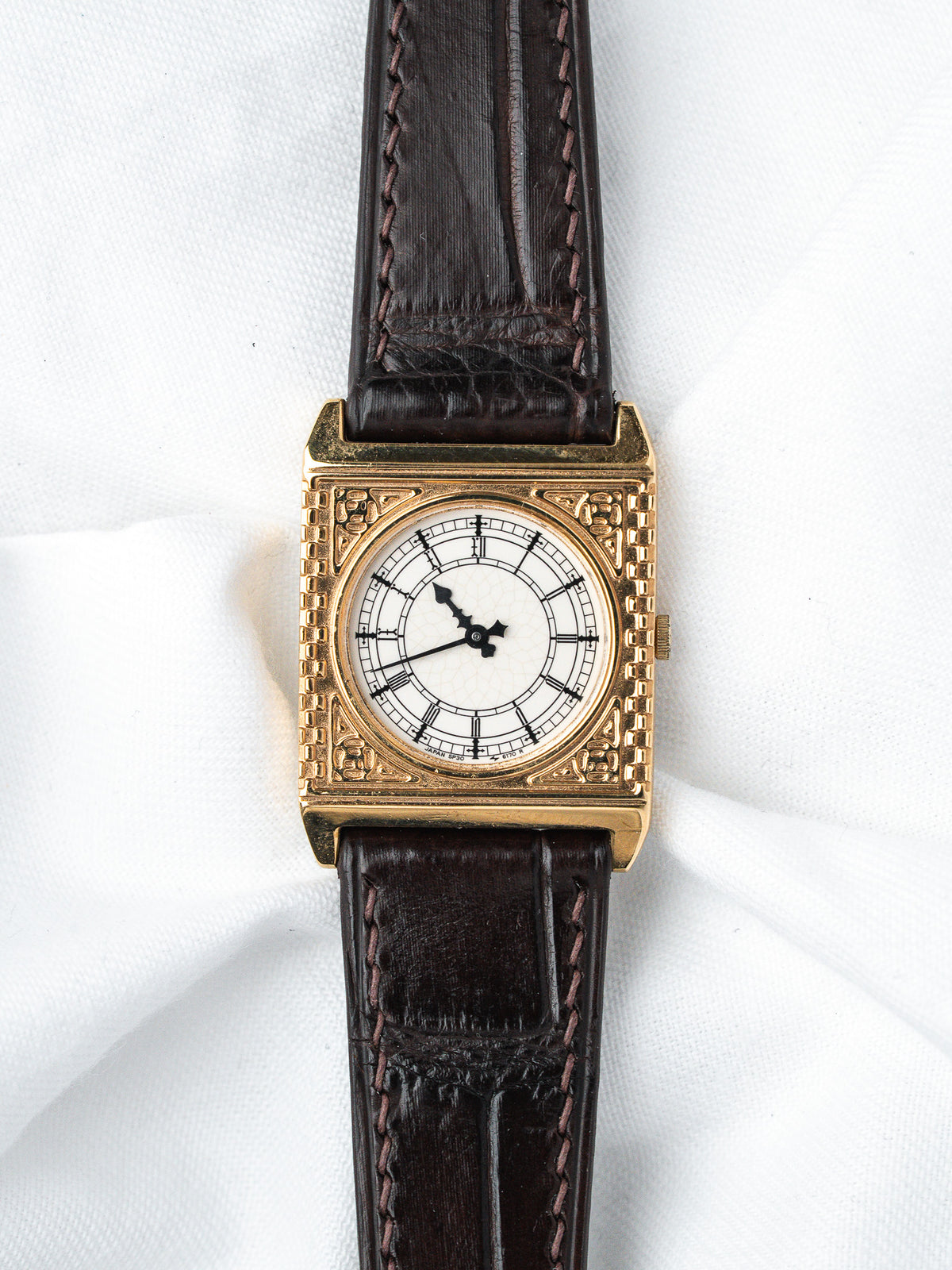 Vintage square gold watch with white dial, black hands, brown leather strap