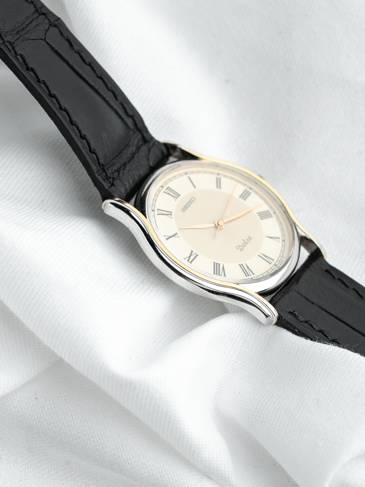 Montre Seiko Dolce vintage, boîtier ovale argenté, cadran crème et bracelet cuir noir