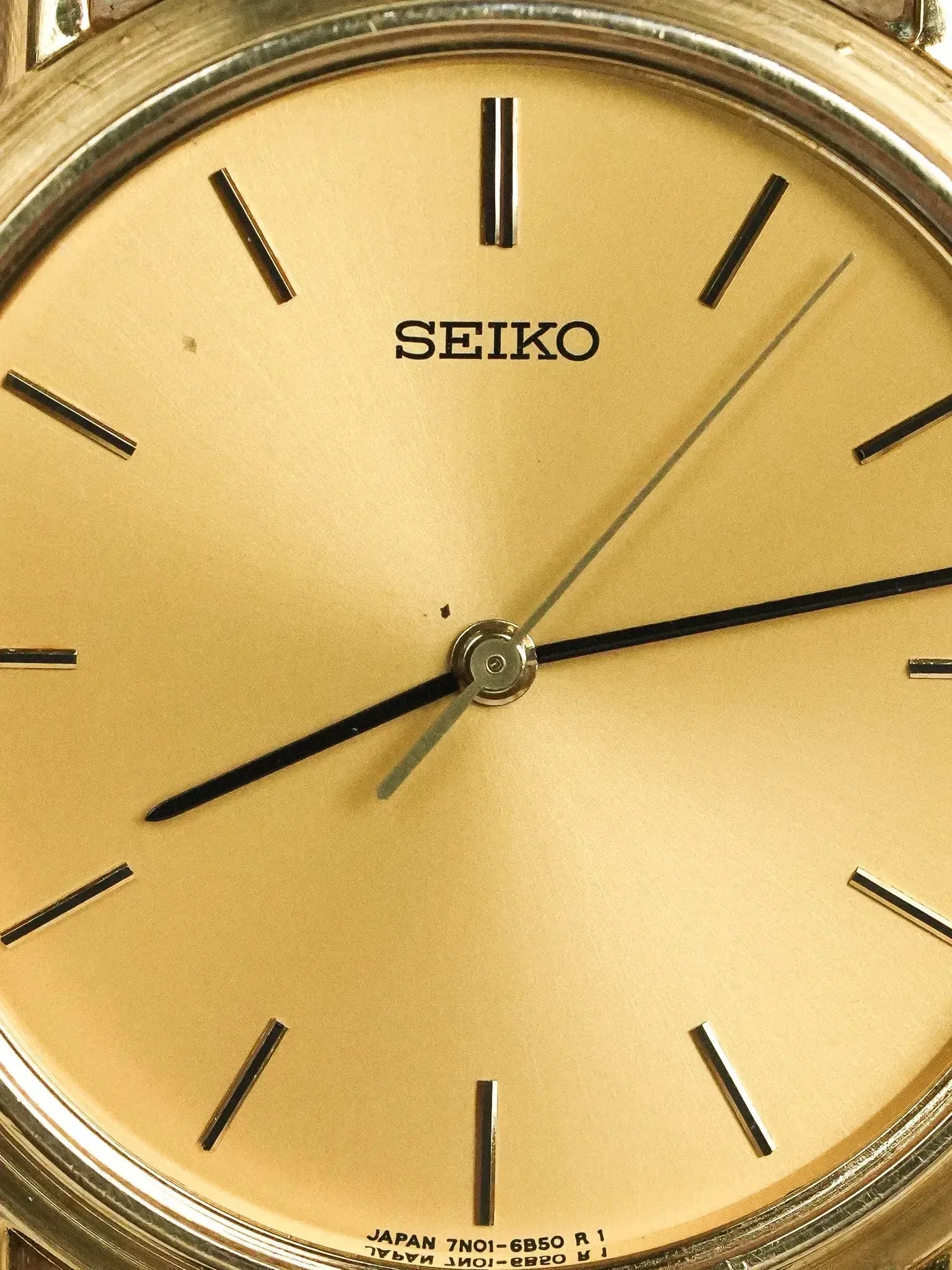 Seiko vintage watch with gold dial, black baton markers, and steel case