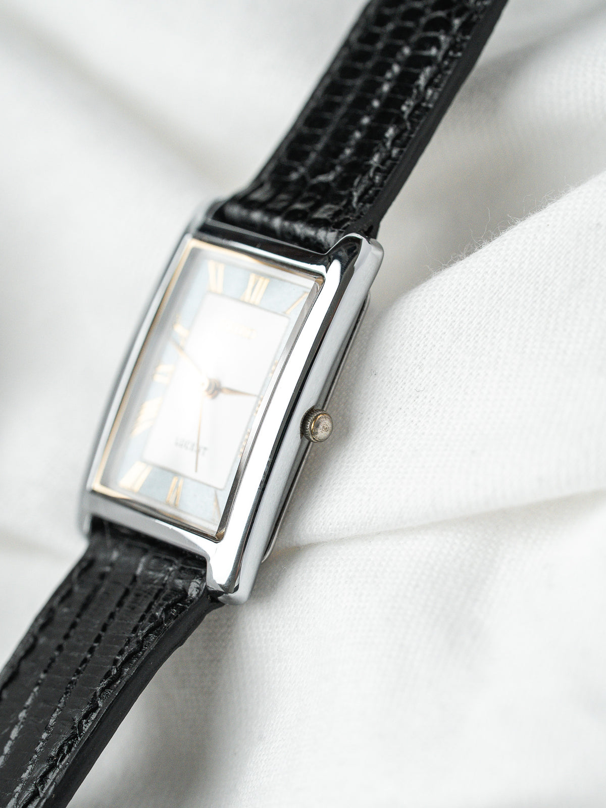 Montre Longines vintage, boîtier rectangulaire argenté, cadran blanc et bracelet cuir noir