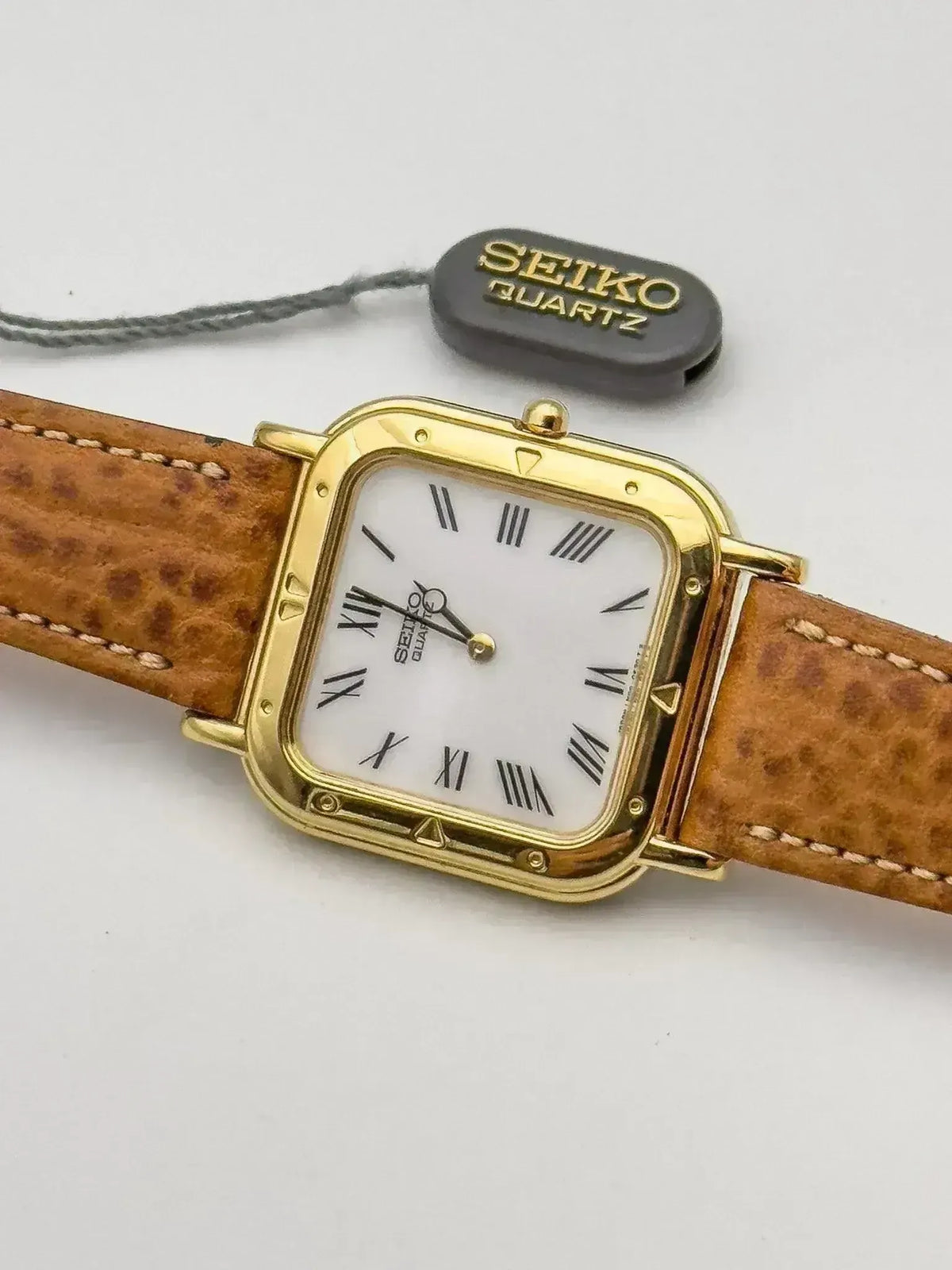 Seiko Quartz vintage watch with gold case, white dial, Roman numerals, brown leather strap