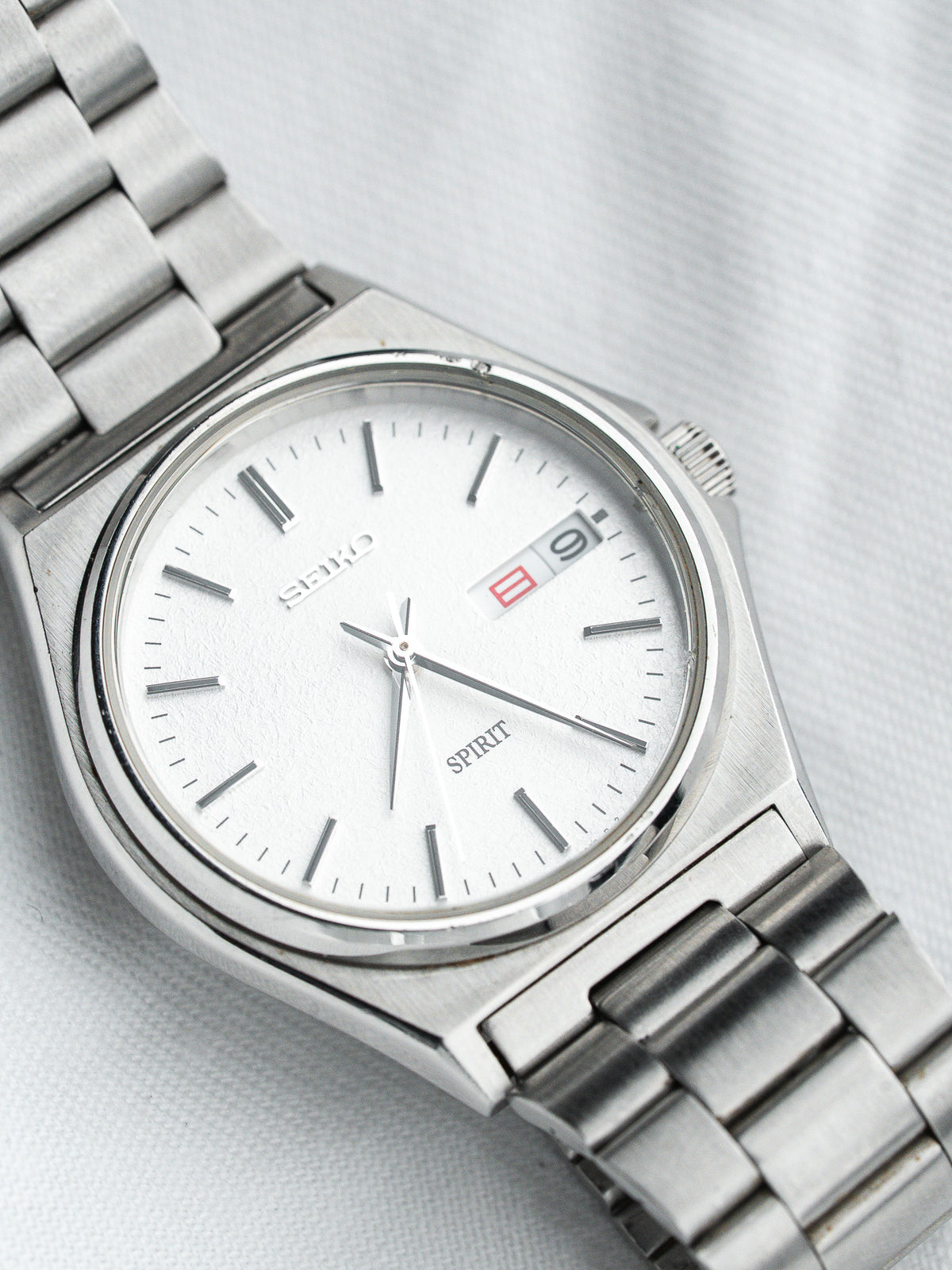Seiko Spirit vintage watch with white dial, steel bracelet, and date display