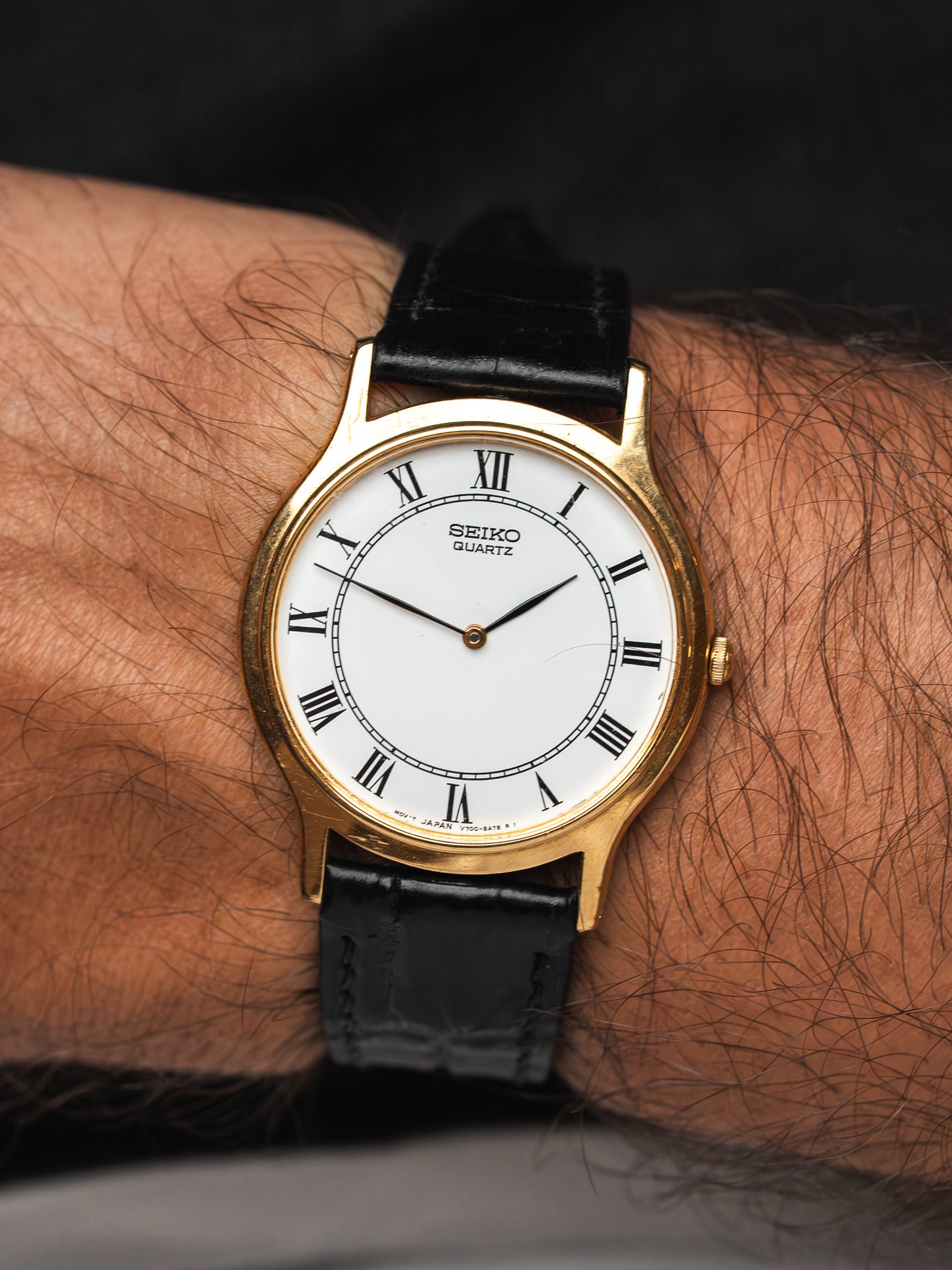 Seiko Quartz vintage watch with gold case, white dial, Roman numerals, black leather strap