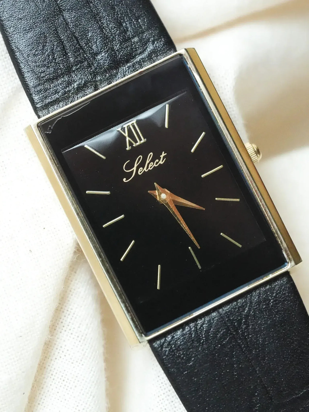 Select vintage watch with black dial, gold hands, rectangular case, black leather strap