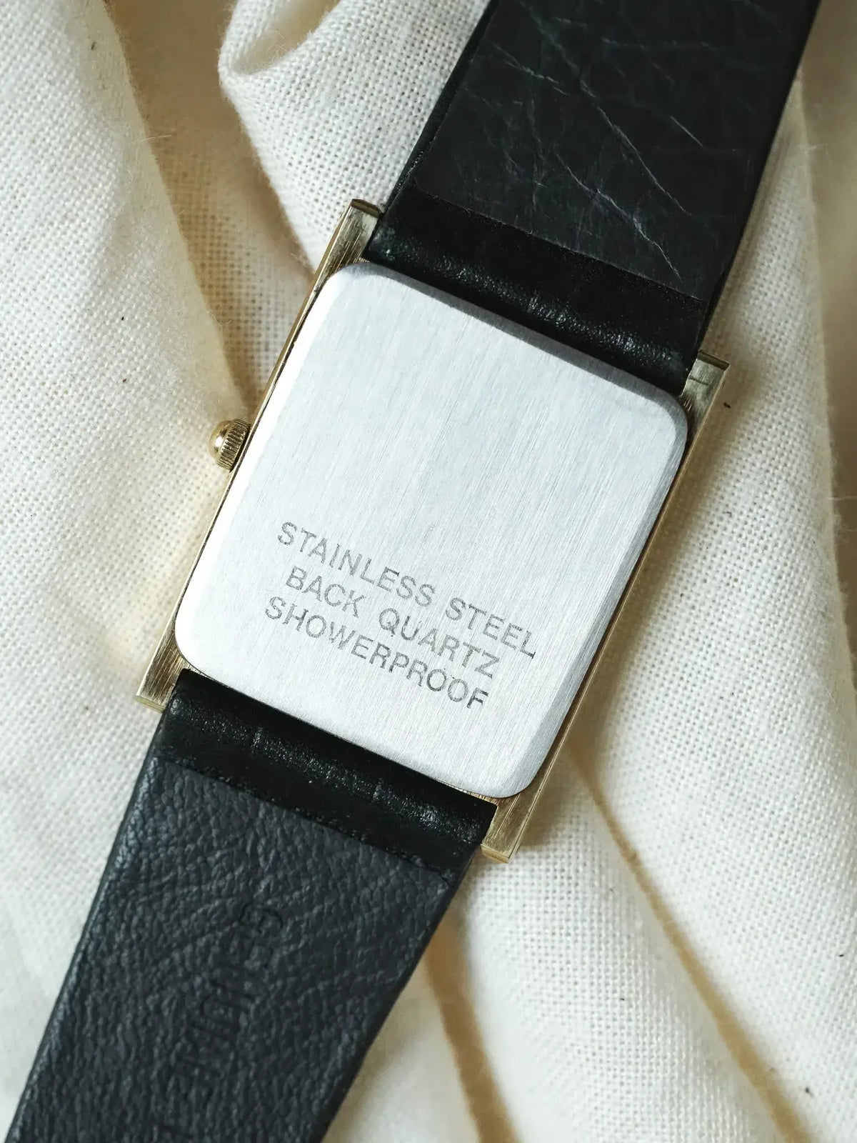 Vintage rectangular watch with stainless steel back, quartz movement, black leather strap