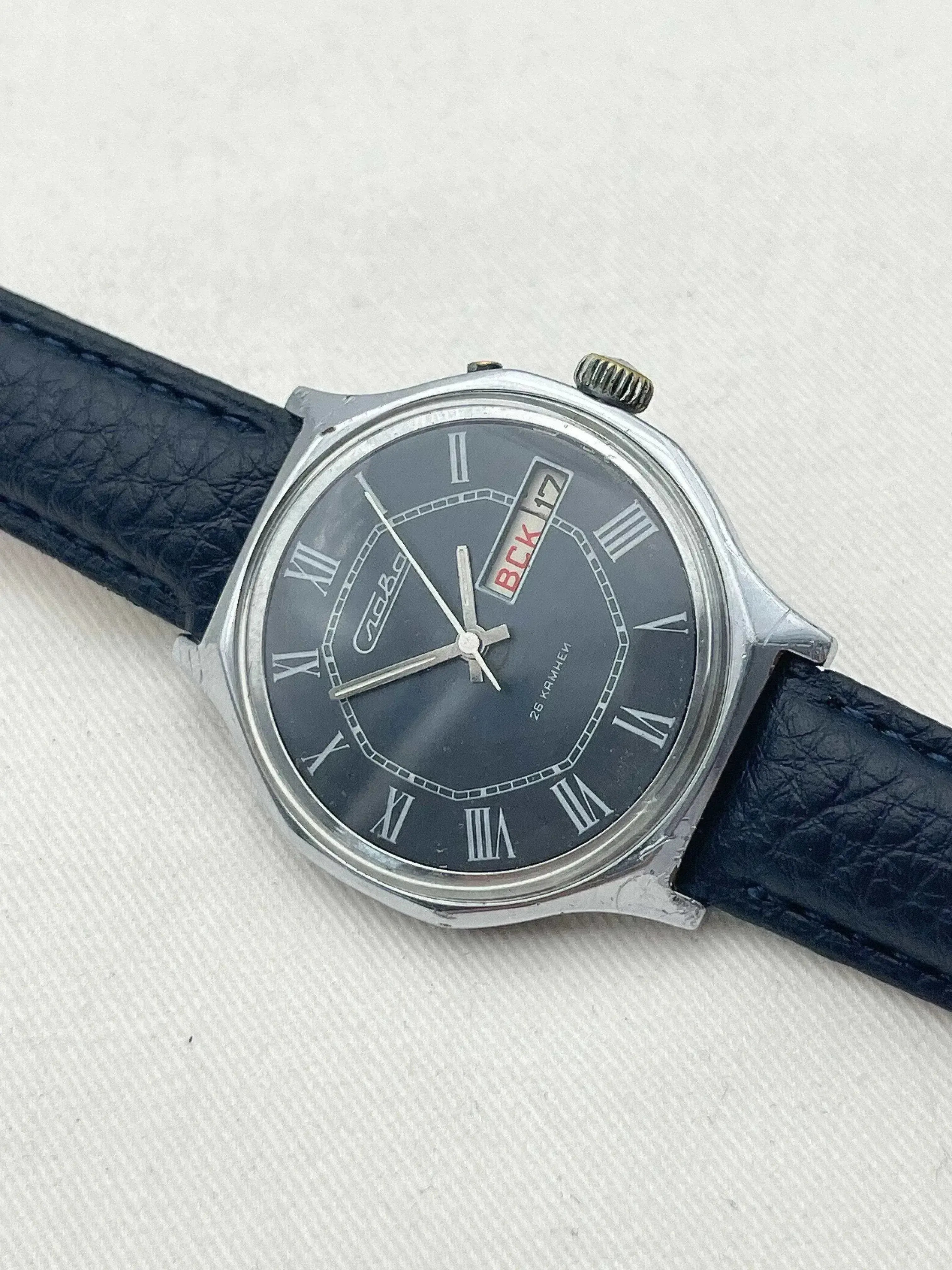 Vintage Vostok watch with dark dial, Roman numerals, and blue leather strap