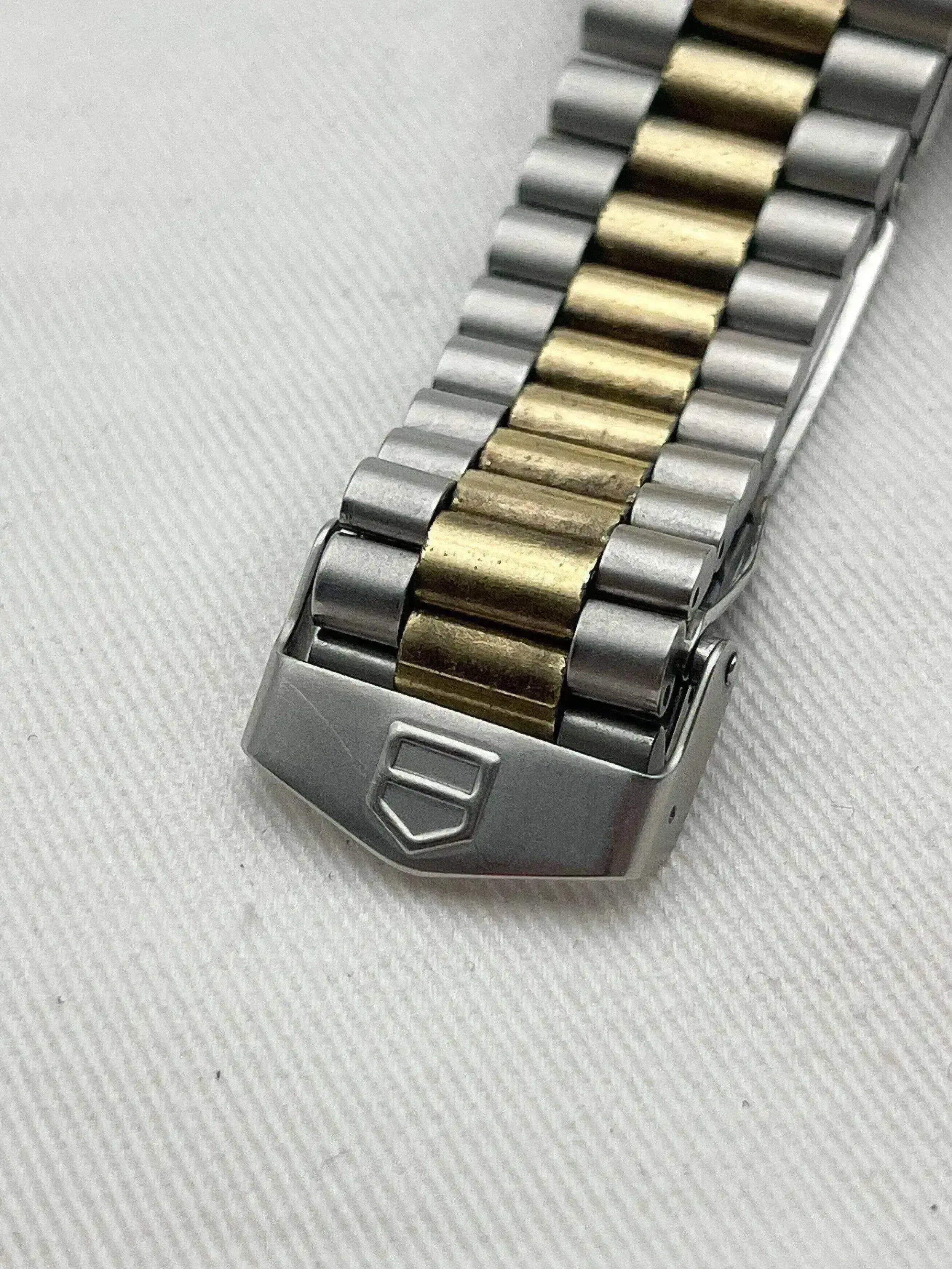 Rolex vintage bracelet in steel and gold, folding clasp with logo, on textured white background