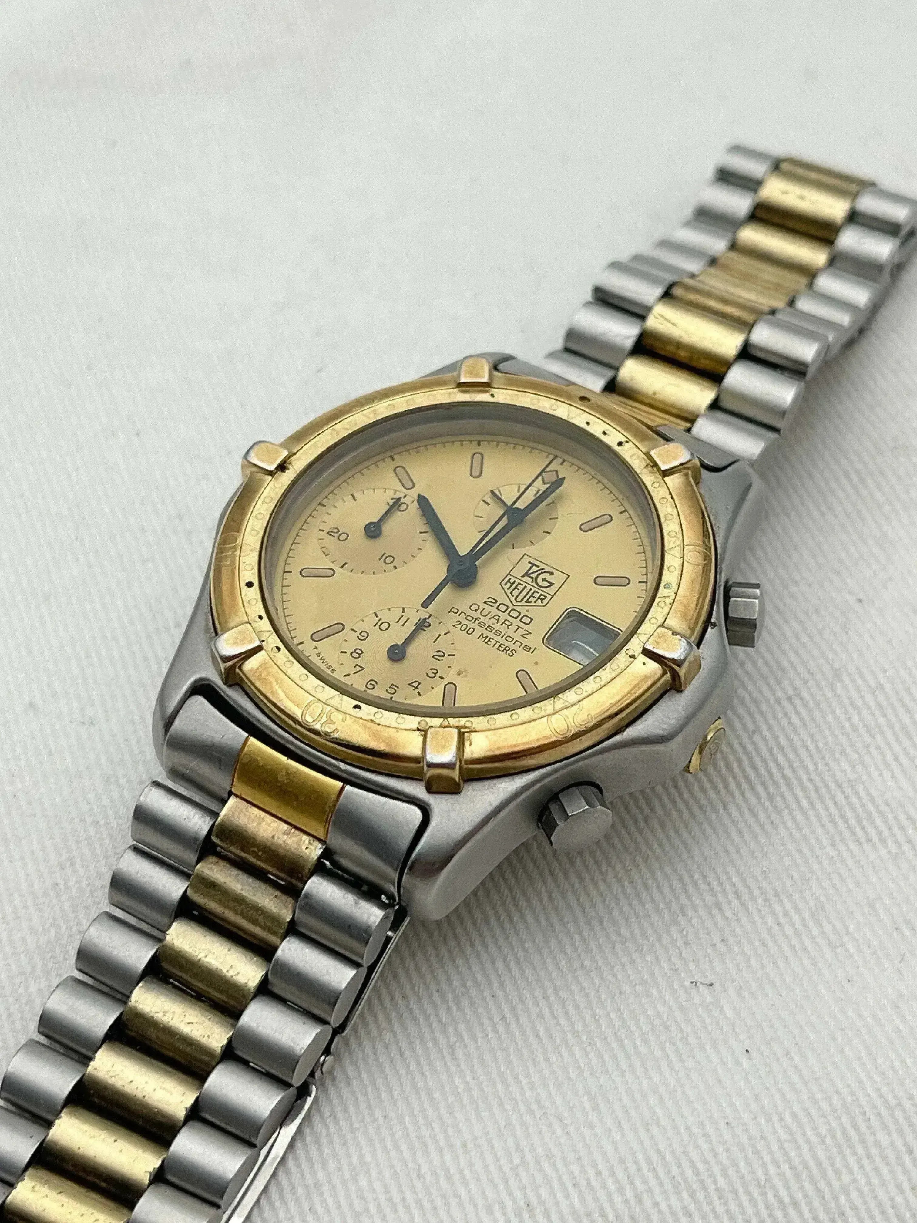 TAG Heuer 2000 Quartz vintage watch, gold and steel bracelet, champagne dial on neutral background