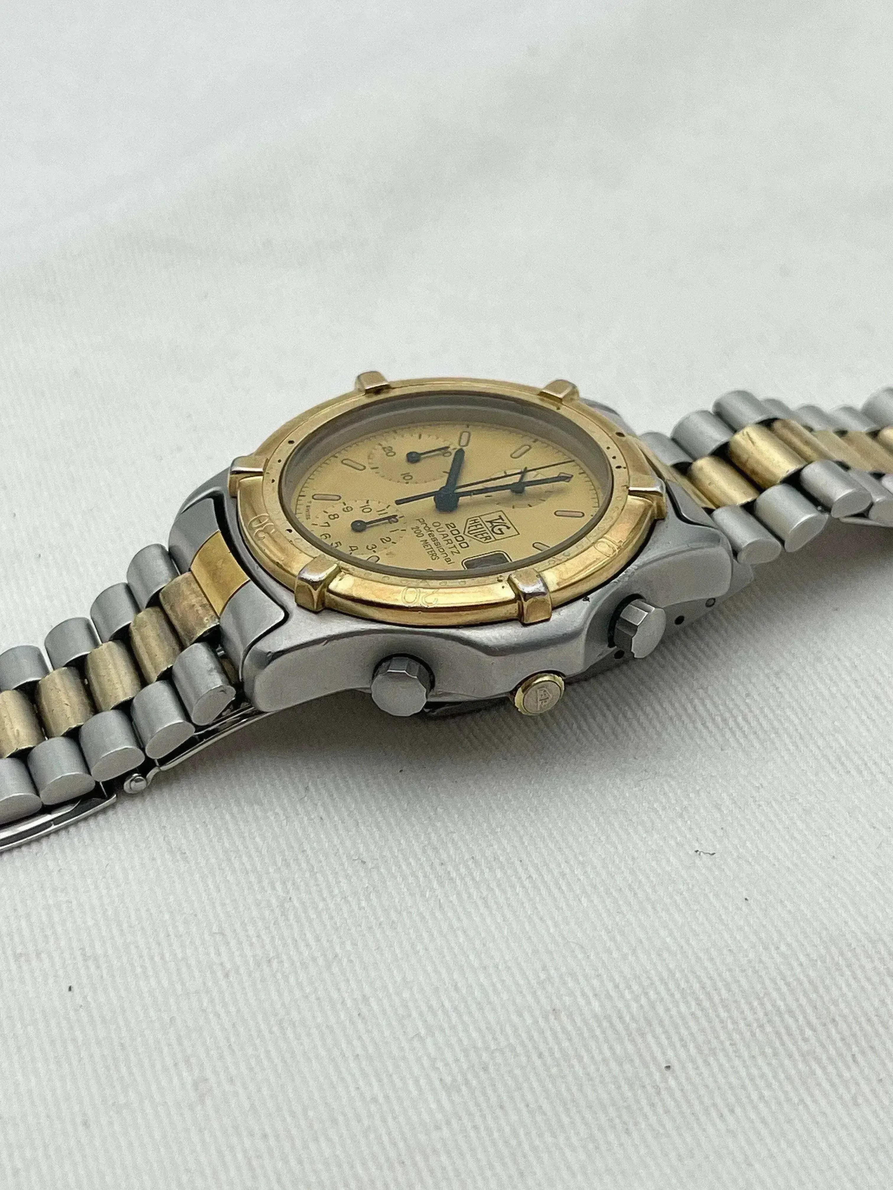 TAG Heuer 2000 Quartz vintage watch with gold and steel bracelet, cream dial on neutral background