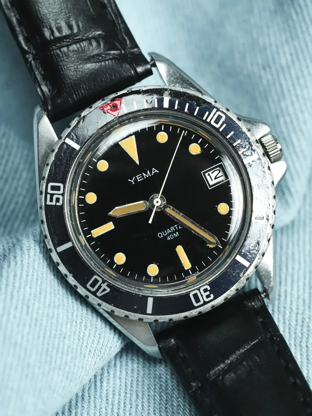 Yema vintage dive watch with black dial, yellow markers, and black leather strap