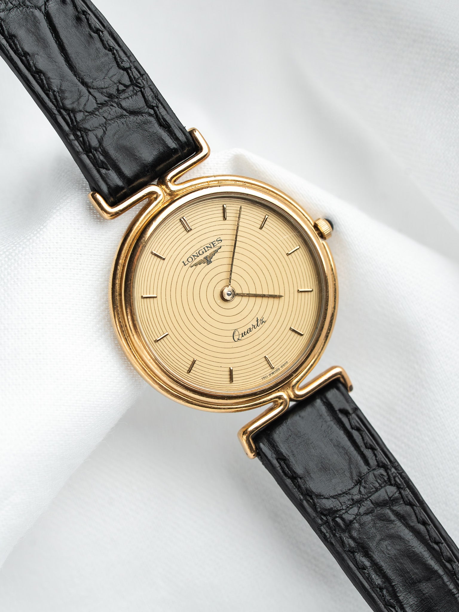 Longines vintage quartz watch with gold case, cream dial, black leather strap