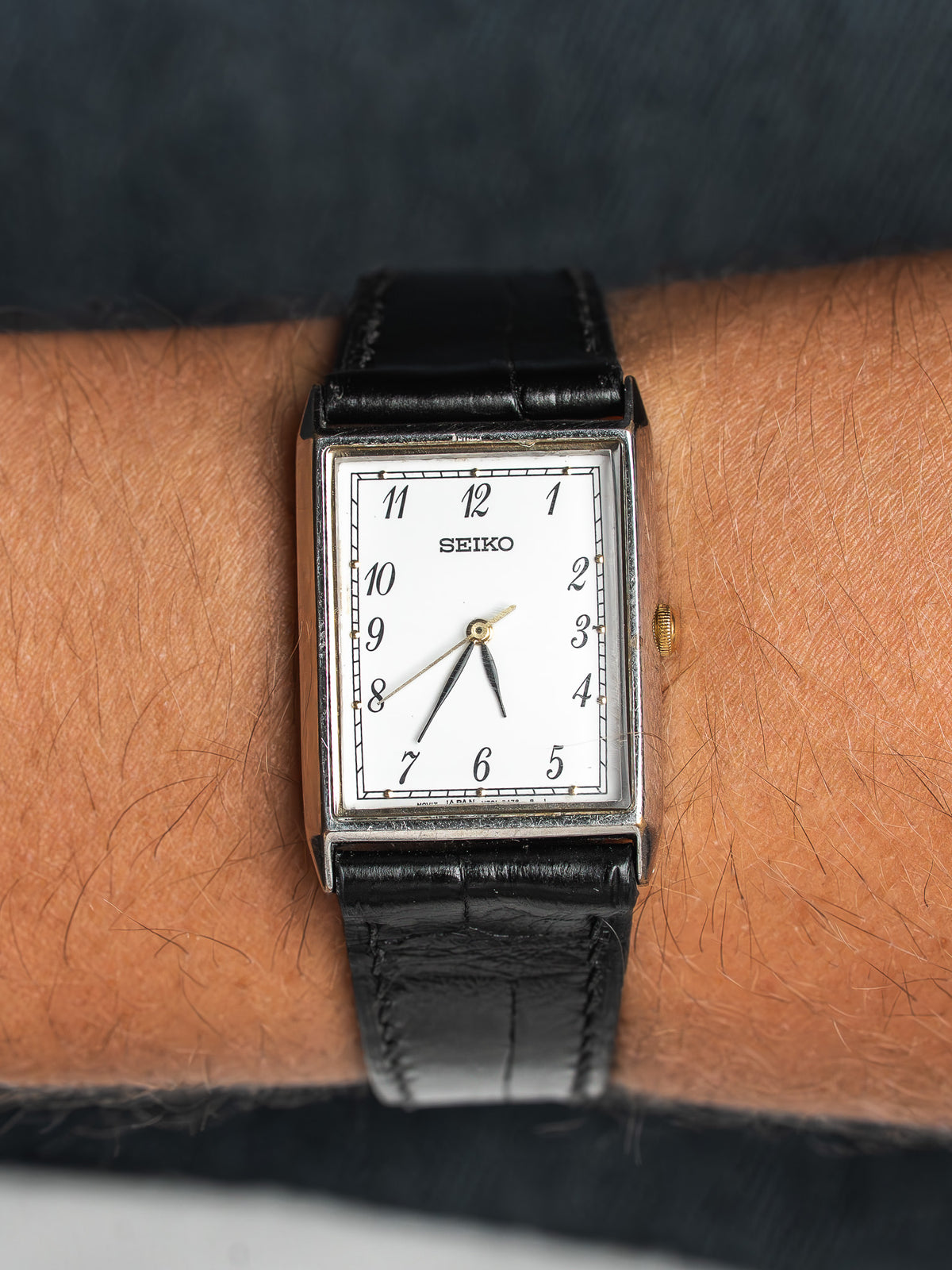 Seiko montre vintage rectangulaire avec cadran blanc, bracelet en cuir noir, portée au poignet