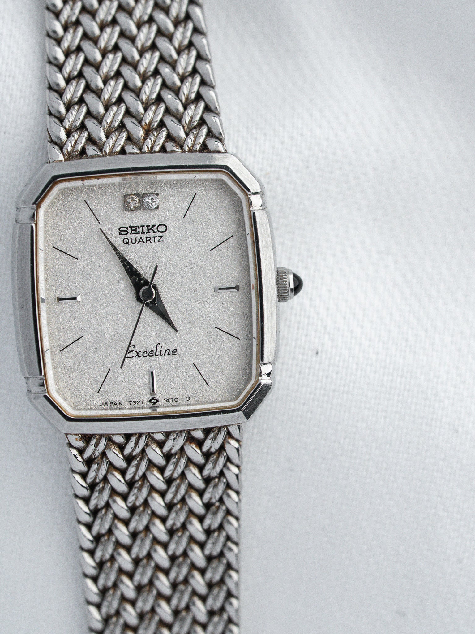 Seiko Quartz Exceline vintage watch with silver dial, diamond markers, and mesh bracelet