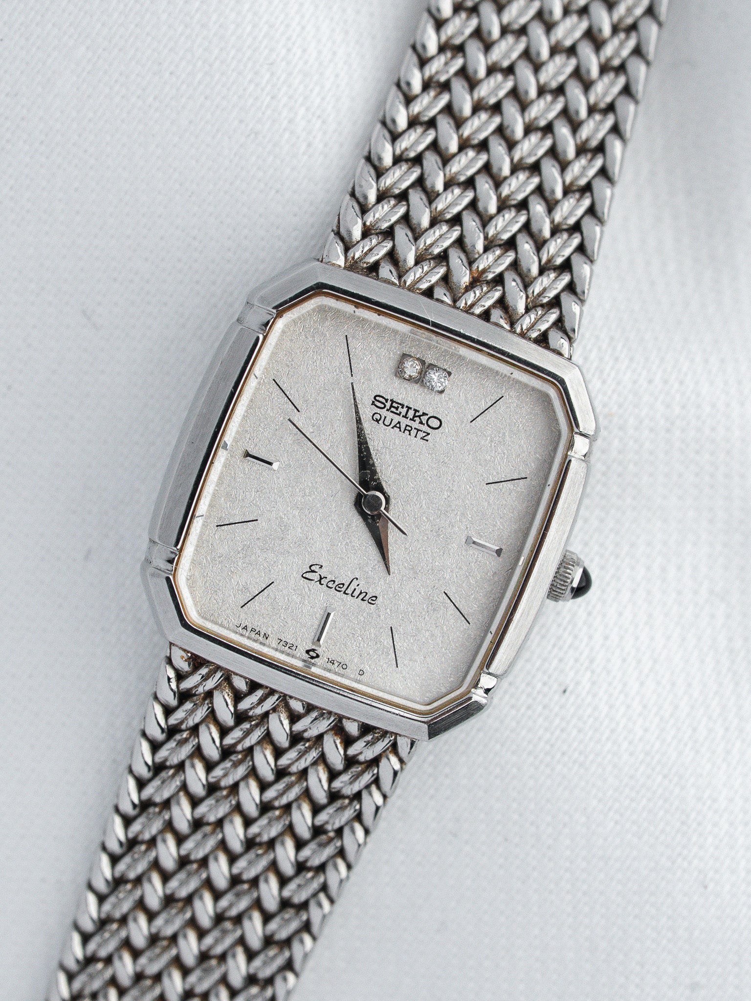 Seiko Exceline vintage quartz watch with silver dial, diamond markers, and mesh bracelet