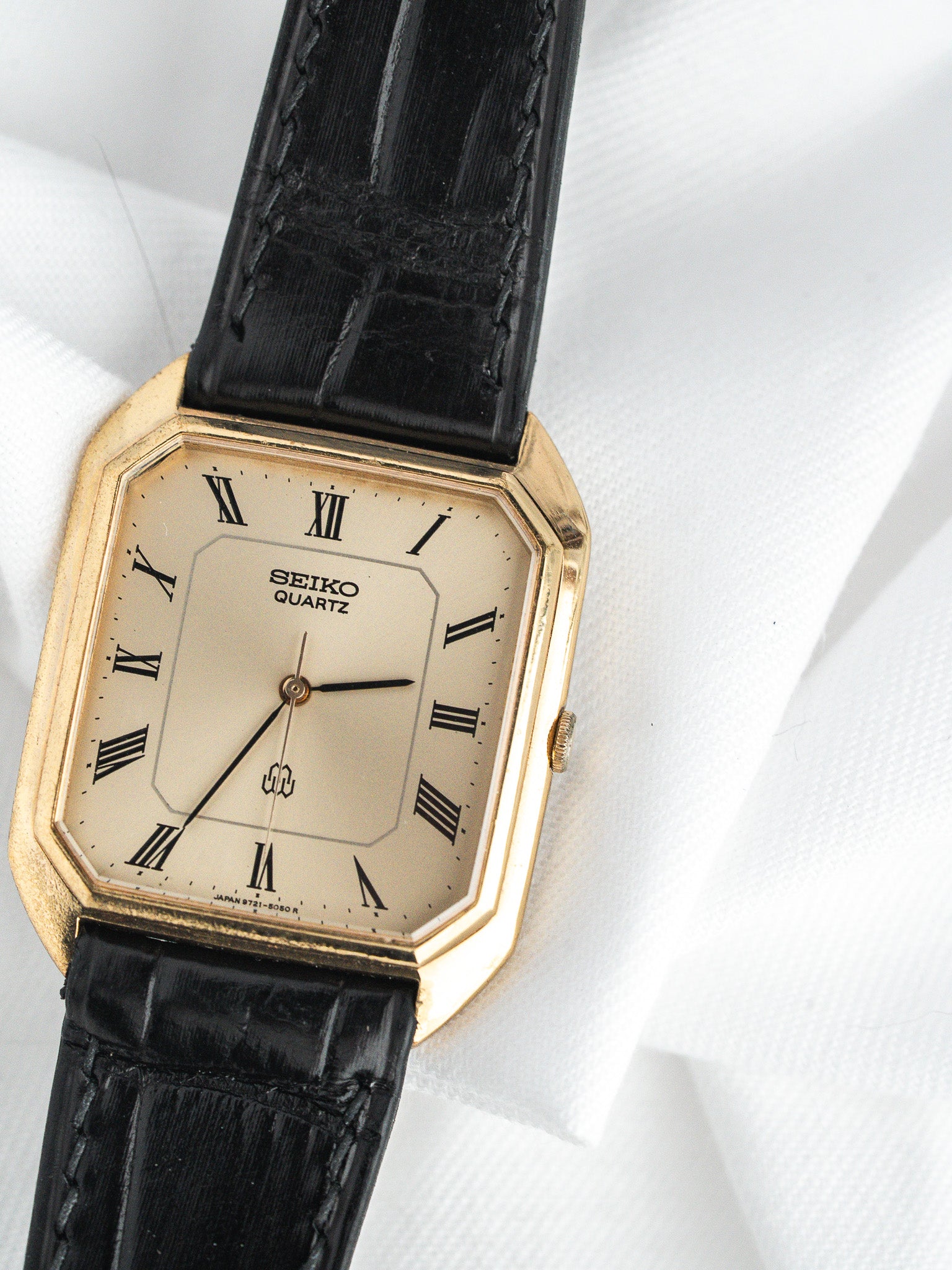 Seiko Quartz vintage watch with gold case, cream dial, Roman numerals, black leather strap