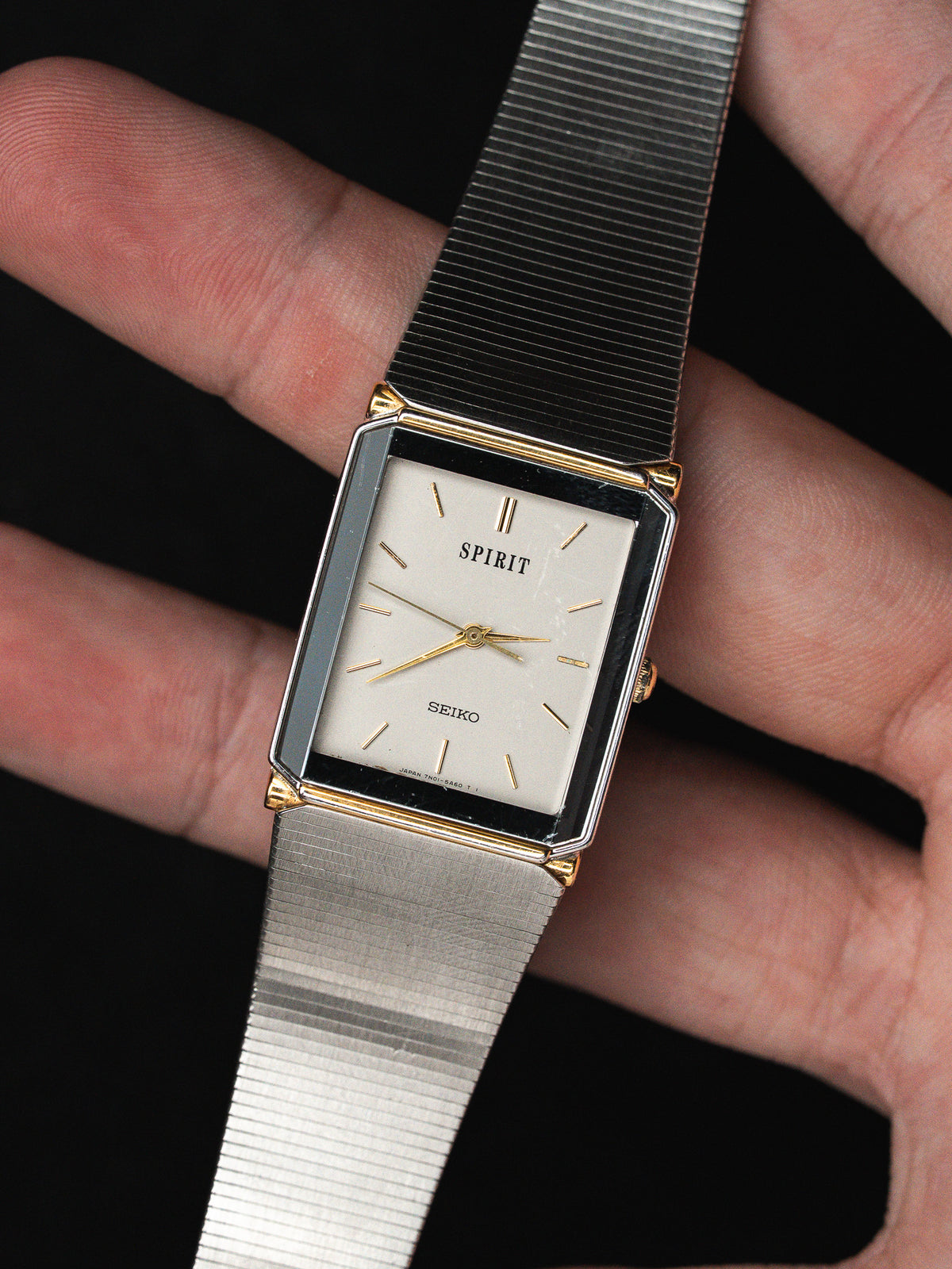 Montre Seiko Spirit vintage rectangulaire avec cadran blanc et bracelet métallique argenté.
