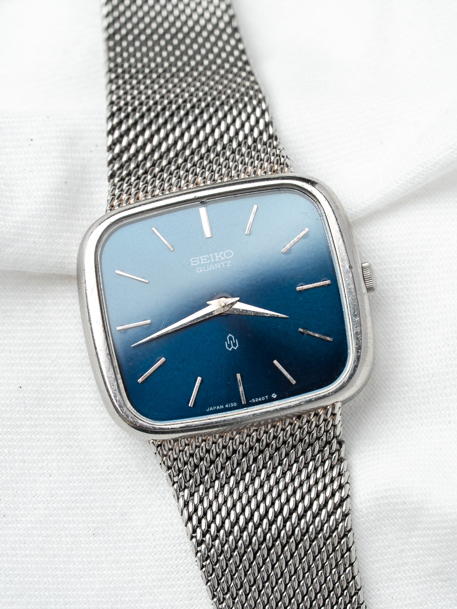 Seiko Quartz vintage watch with blue gradient dial and mesh bracelet on white background
